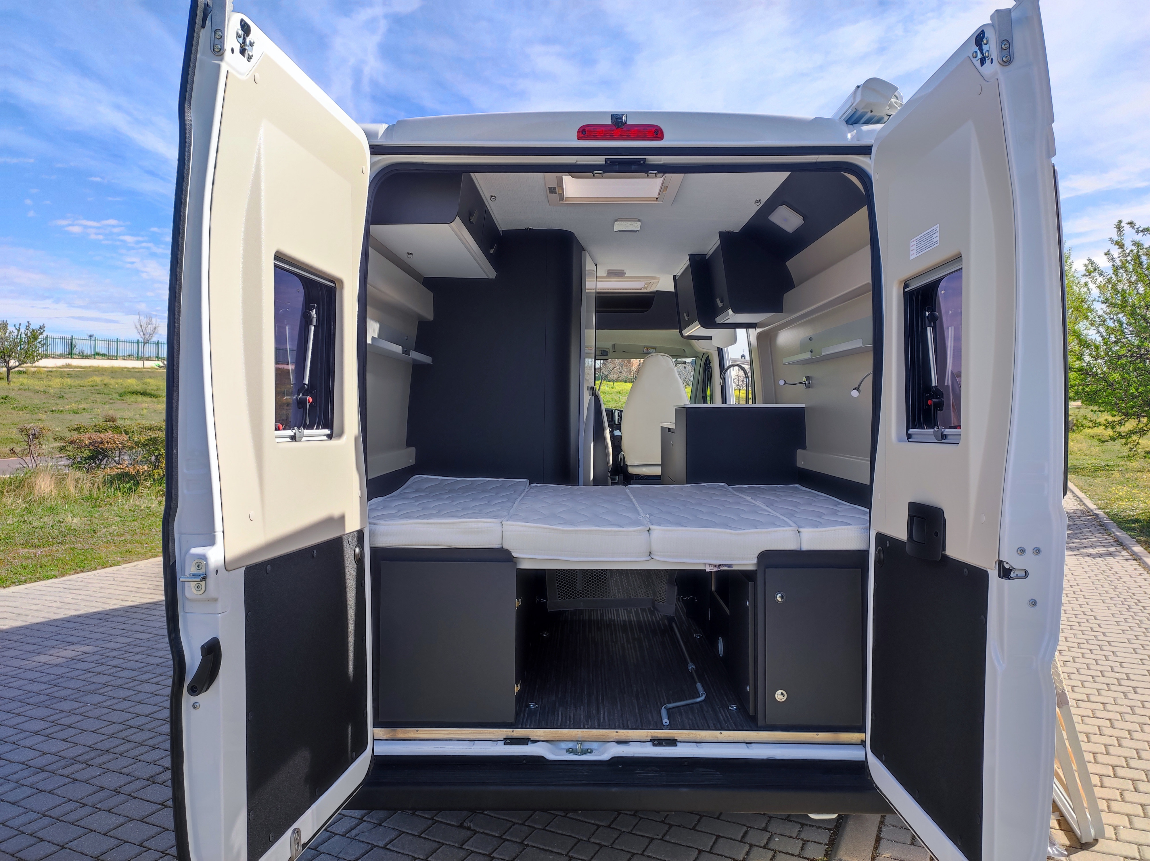 Open rear view of a modern **RV rental**, showcasing its comfortable bed, ample storage, and compact kitchen. Ideal for road trips.. Fiat MCLOUISE /MENPHYS3 MAXI 2024