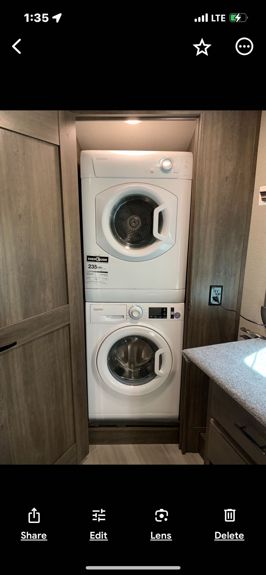 Compact Splendide stacked washer dryer unit, a convenient laundry amenity inside an RV rental.. Grand Design Solitude 2022