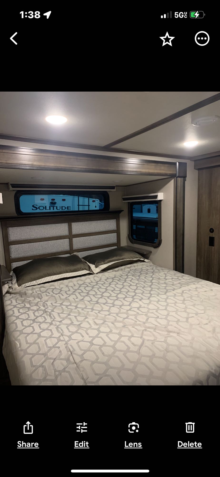 Cozy RV rental bedroom with modern decor and comfortable bed. Perfect for your next mobile adventure in a Grand Design Solitude.. Grand Design Solitude 2022