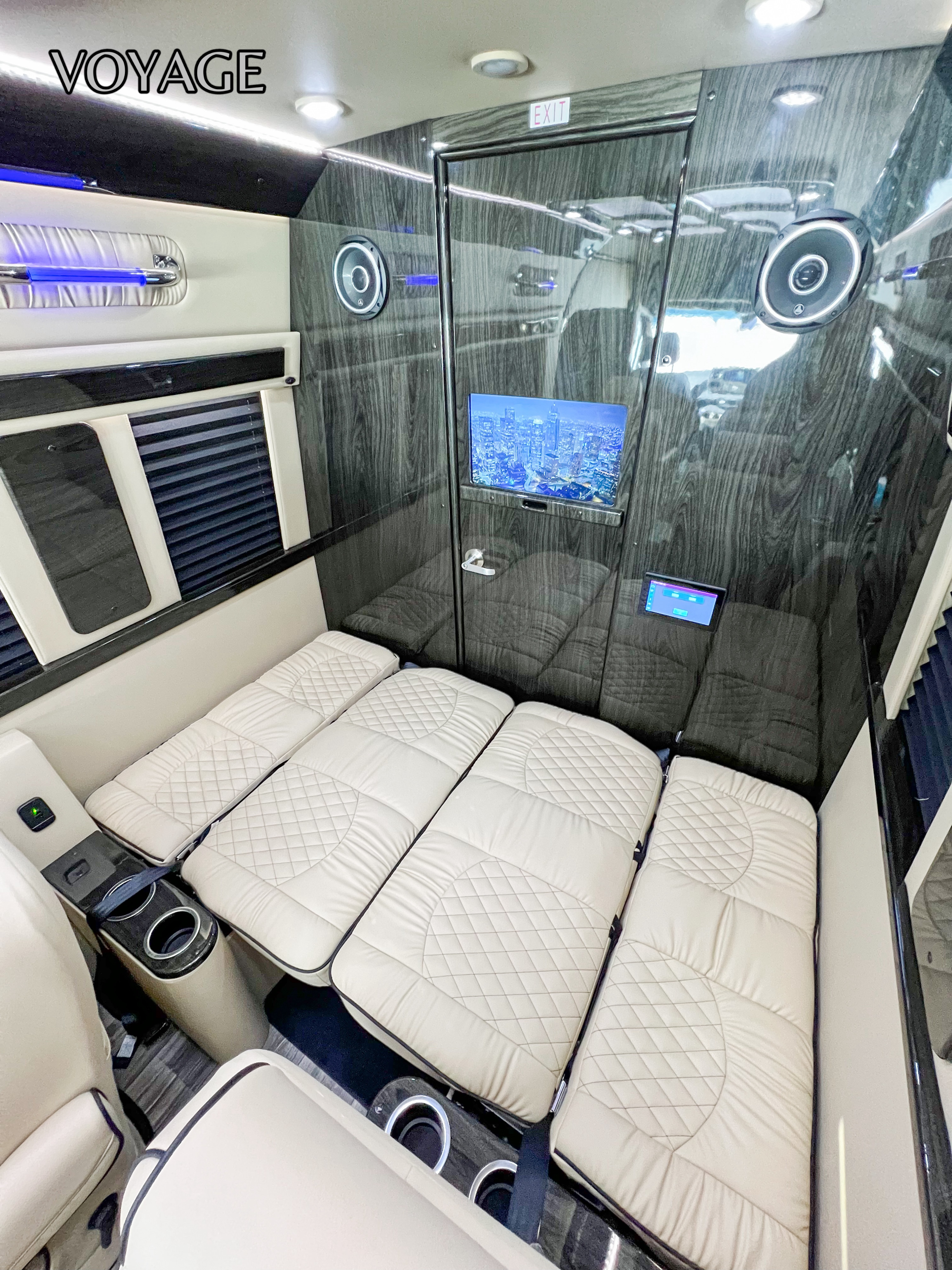 This luxury RV rental interior features plush, convertible seating/beds, a modern entertainment system, and elegant wood finishes.. Mercedes-Benz Sprinter 419 LWB High Roof 2024
