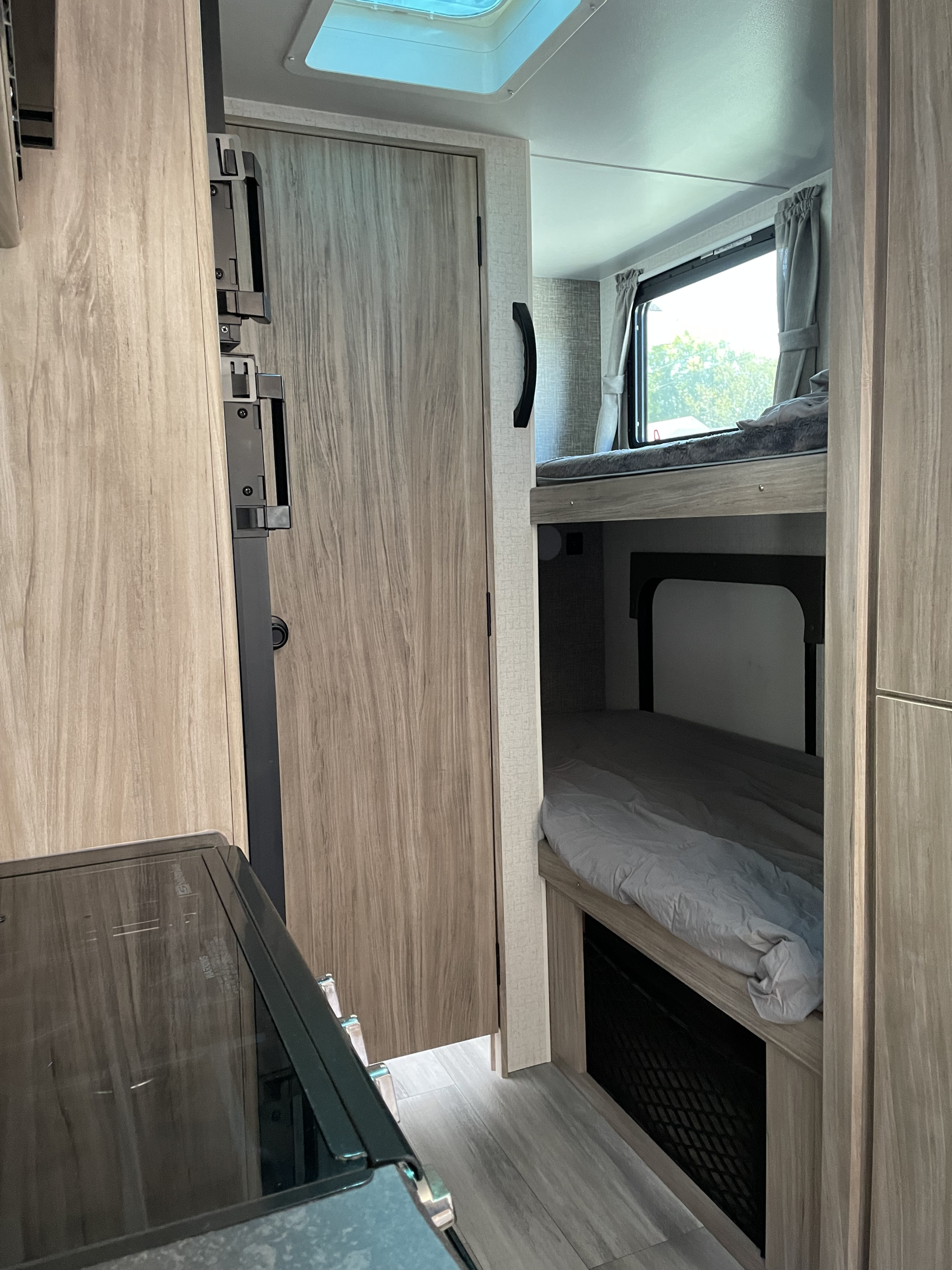 Cozy RV rental interior featuring bunk beds, a kitchen counter, and ample storage for your next adventure.. Minnie Micro Minnie 2022