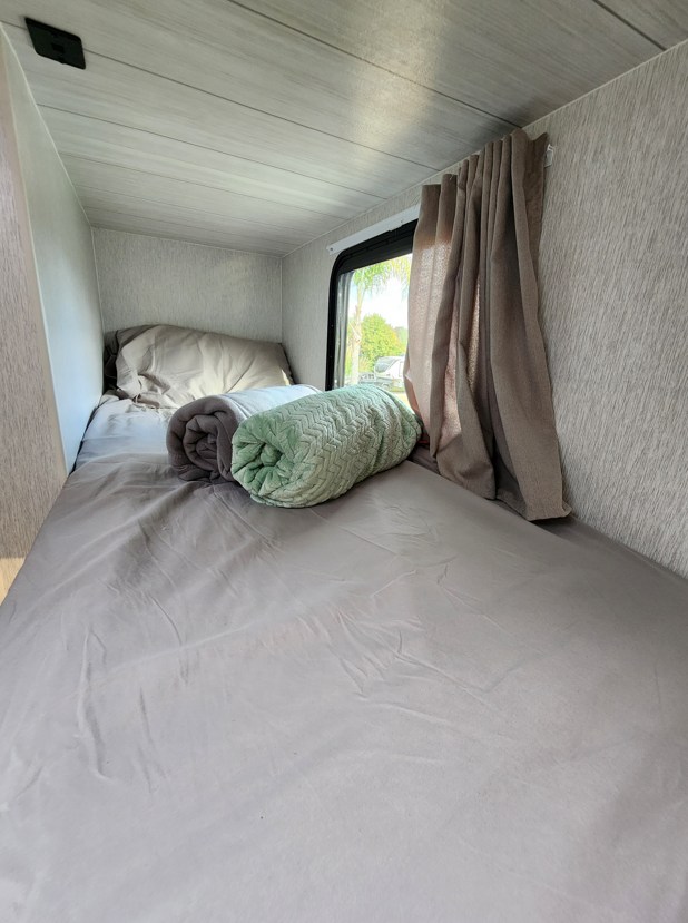 Cozy RV rental bunk bed with soft bedding & window view. Perfect for travel comfort.. Other Other 2024