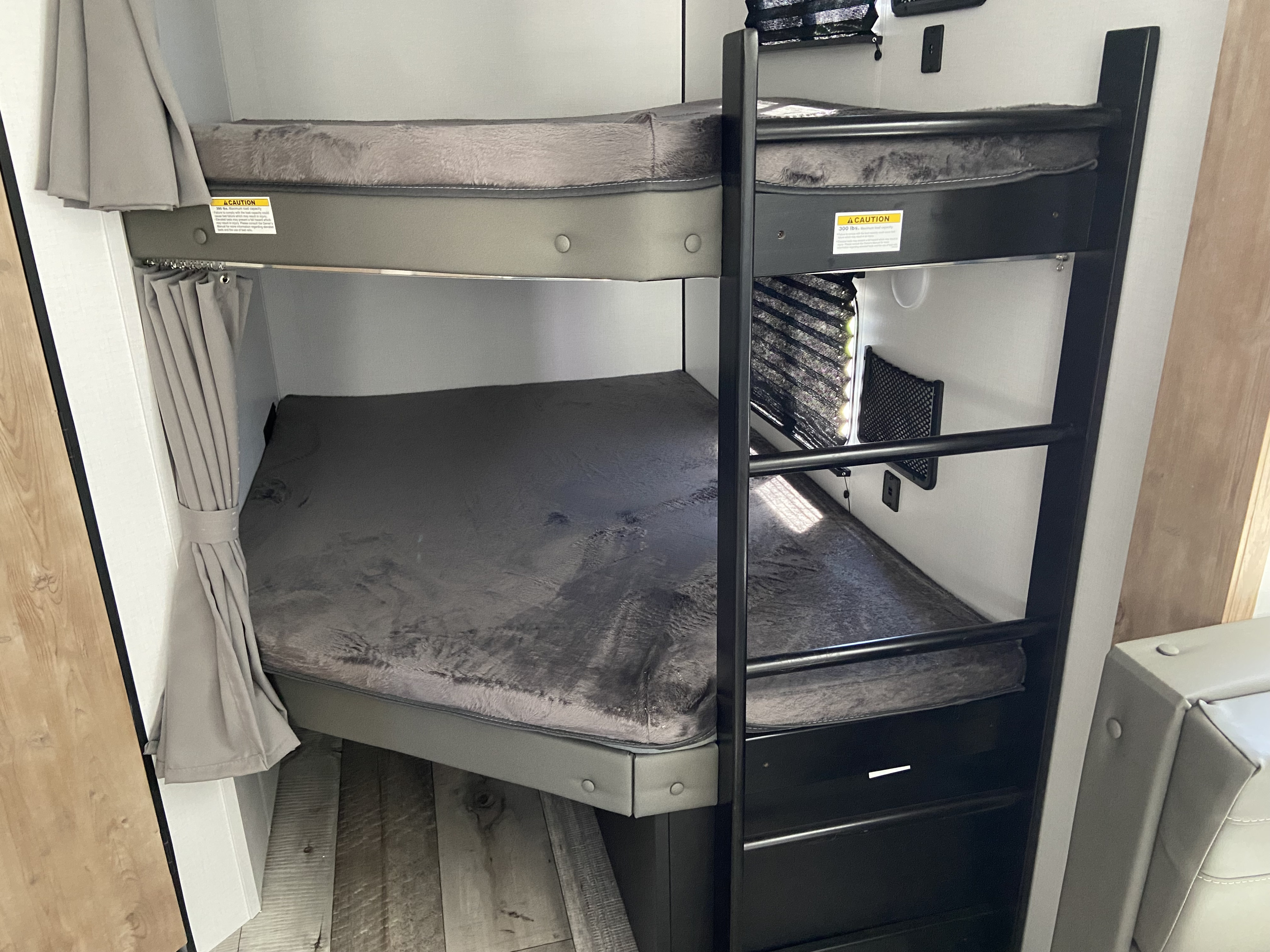 RV rental interior: comfortable bunk beds with fuzzy mattresses, ladder, & privacy curtains. Great for travel.. Keystone RV Springdale 2022