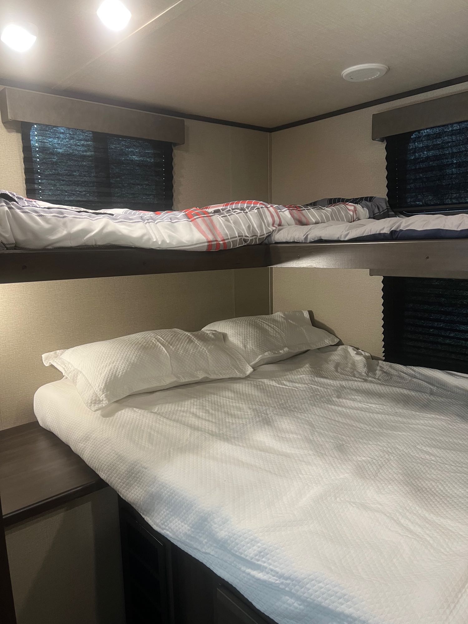 RV rental interior: cozy bunk beds with white & plaid bedding, ideal for family trips.. Grand Design Transcend Xplor 2022