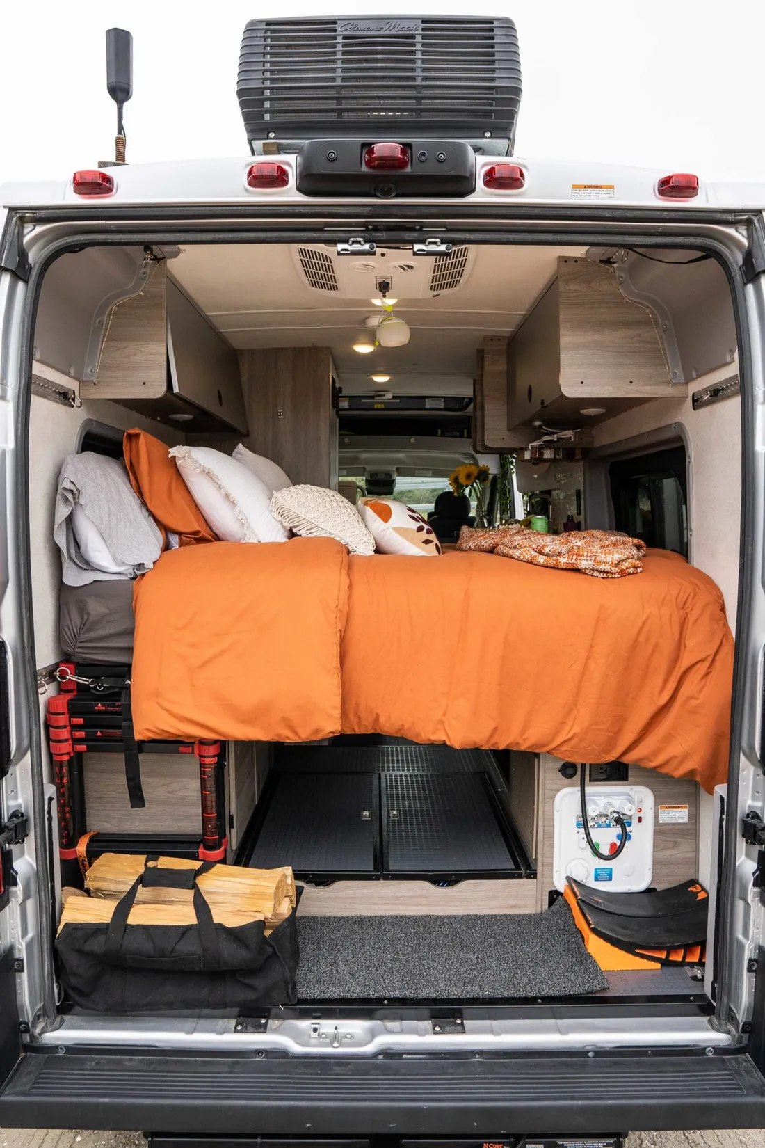 Camper van interior: spacious RV rental bed with storage below for gear & firewood. Ideal for road trip adventures.. Winnebago Solis 2022