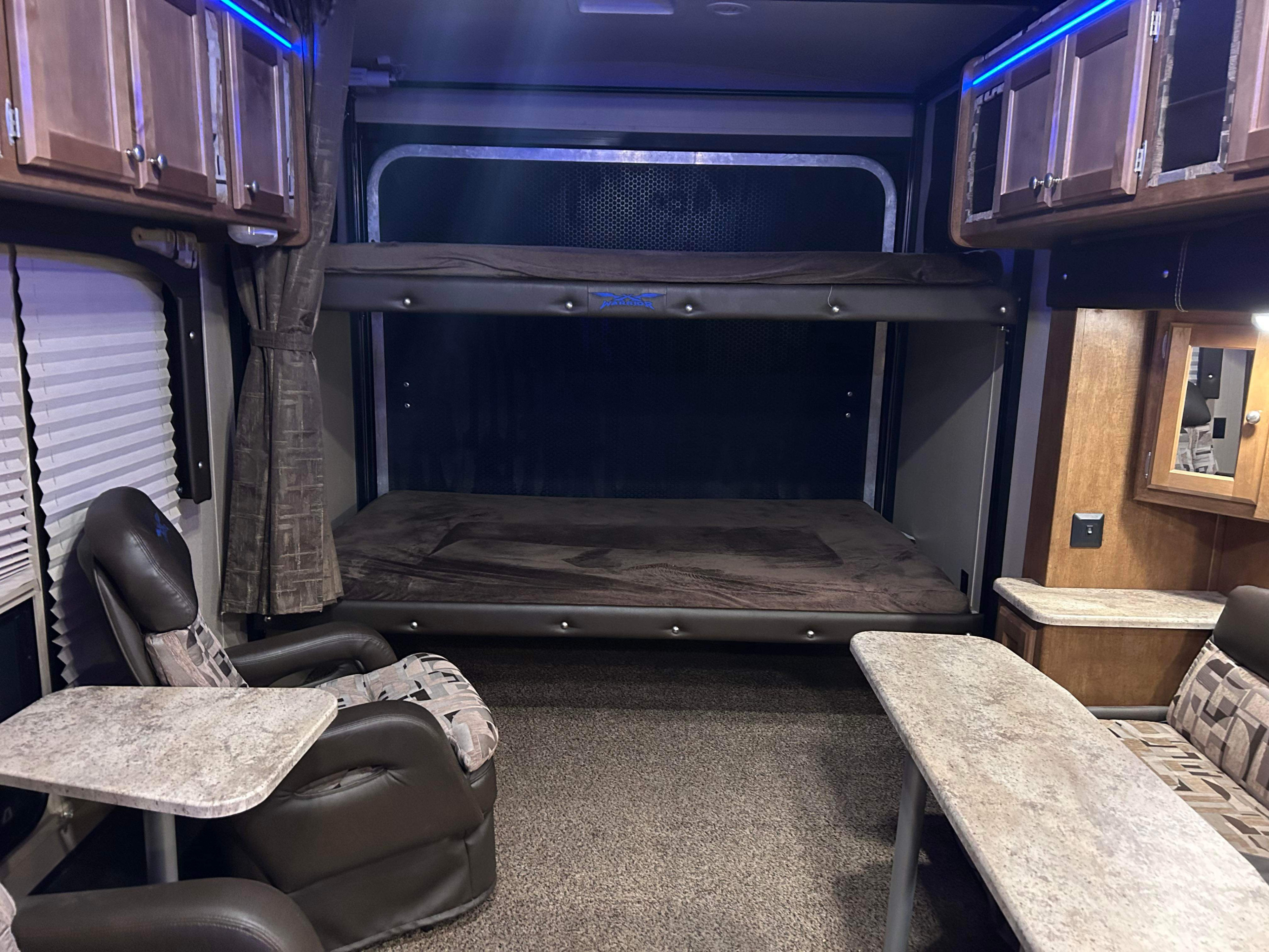 Spacious rv rental interior featuring comfortable seating, bunk beds, overhead cabinets, and blue ambient lighting.. Weekend Warrior 2600fs 2017