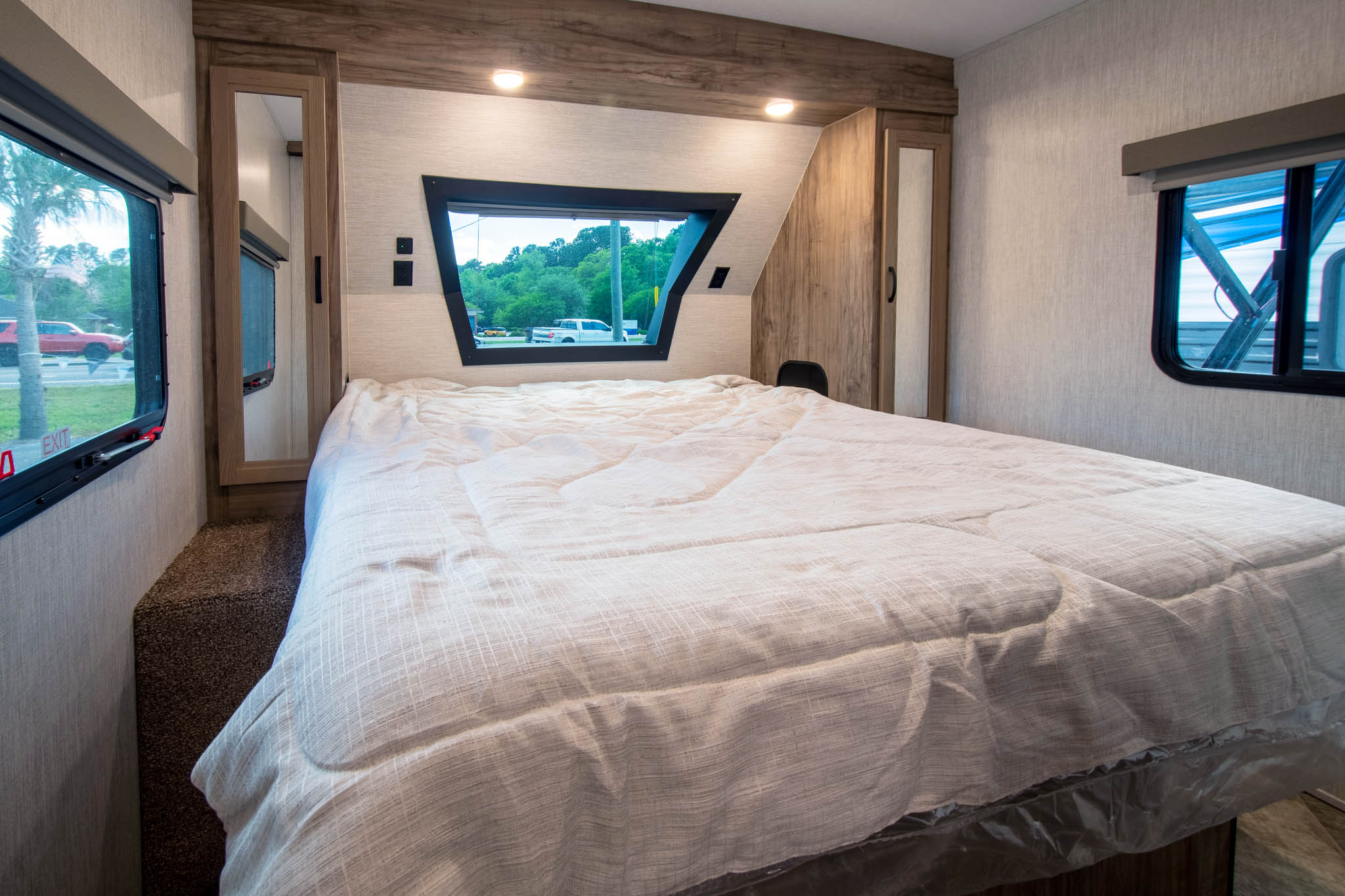 Comfortable RV rental bedroom with large bed, windows, built-in storage, and modern lighting. Ideal for your next trip.. Palomino Solaire Ultra Lite 2023