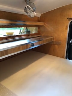 Inside a compact RV rental: wood interior, bed, counter, window & fan. Ideal for road trips.. Tiny Heirloom Teardrop 2023