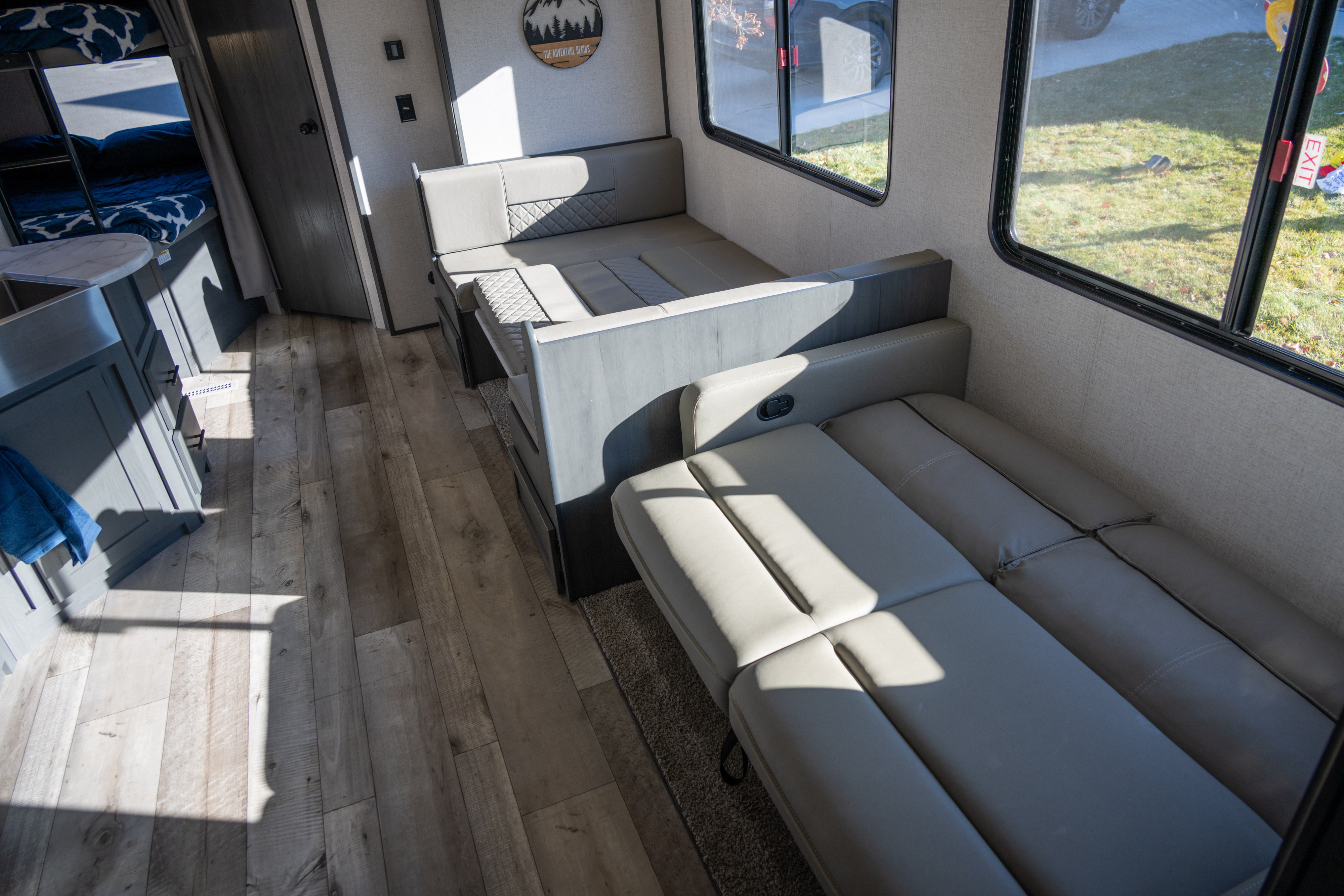 Experience the comforts of this RV rental's interior, showcasing modern bunk beds, a convertible dinette, and plush sofa seating for travel.. Aspen Trail Aspen Trail Trailer 2022