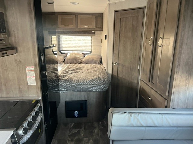 This RV rental interior features a comfortable bed, full kitchen, and storage, perfect for your next road trip.. Gulf Stream Conquest 6237LE 2024