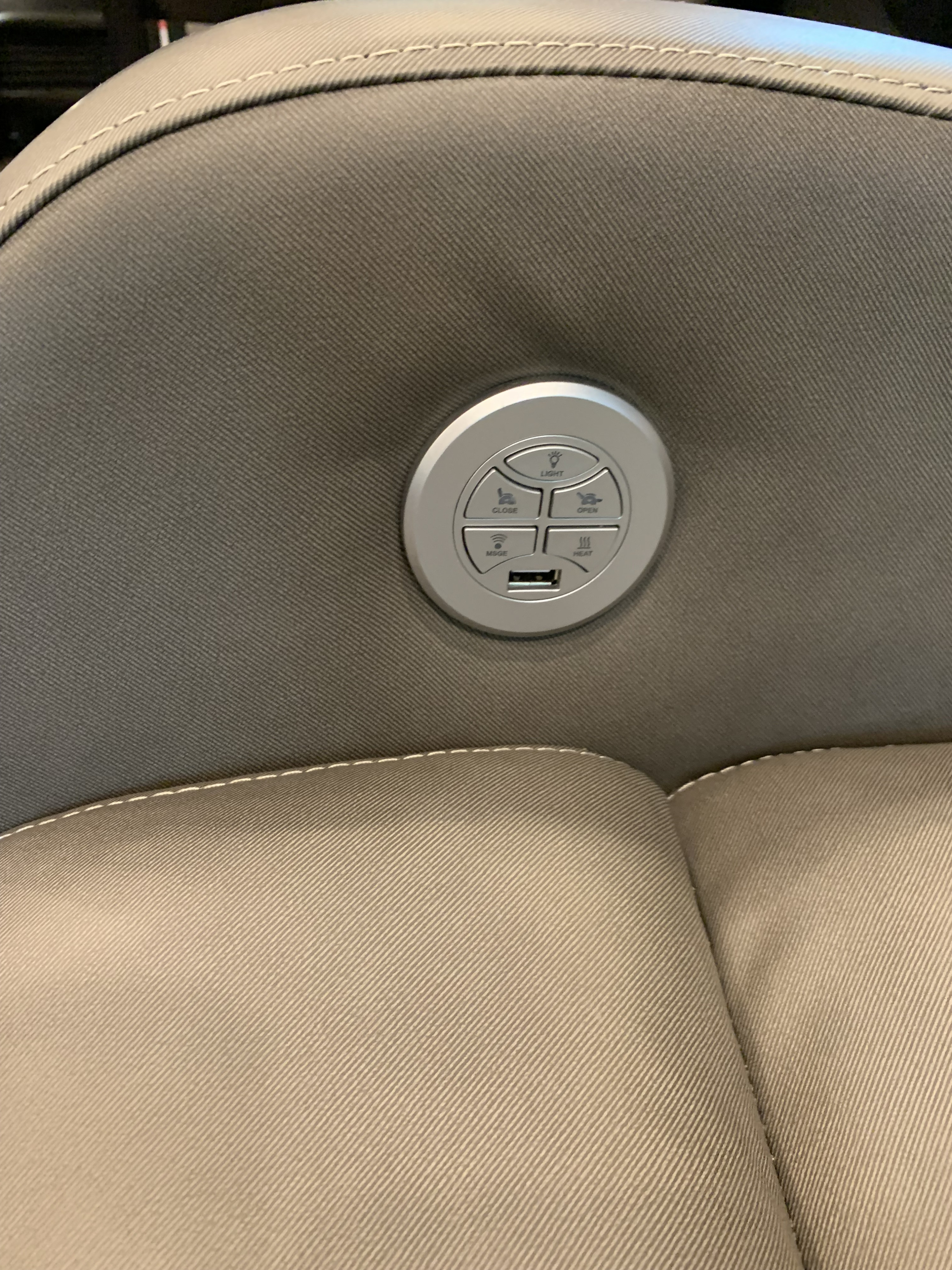 Convenient RV rental seating: Built-in control panel with light, recline (open/close), massage, heat, and USB port on beige fabric.. Jayco North Point 2021
