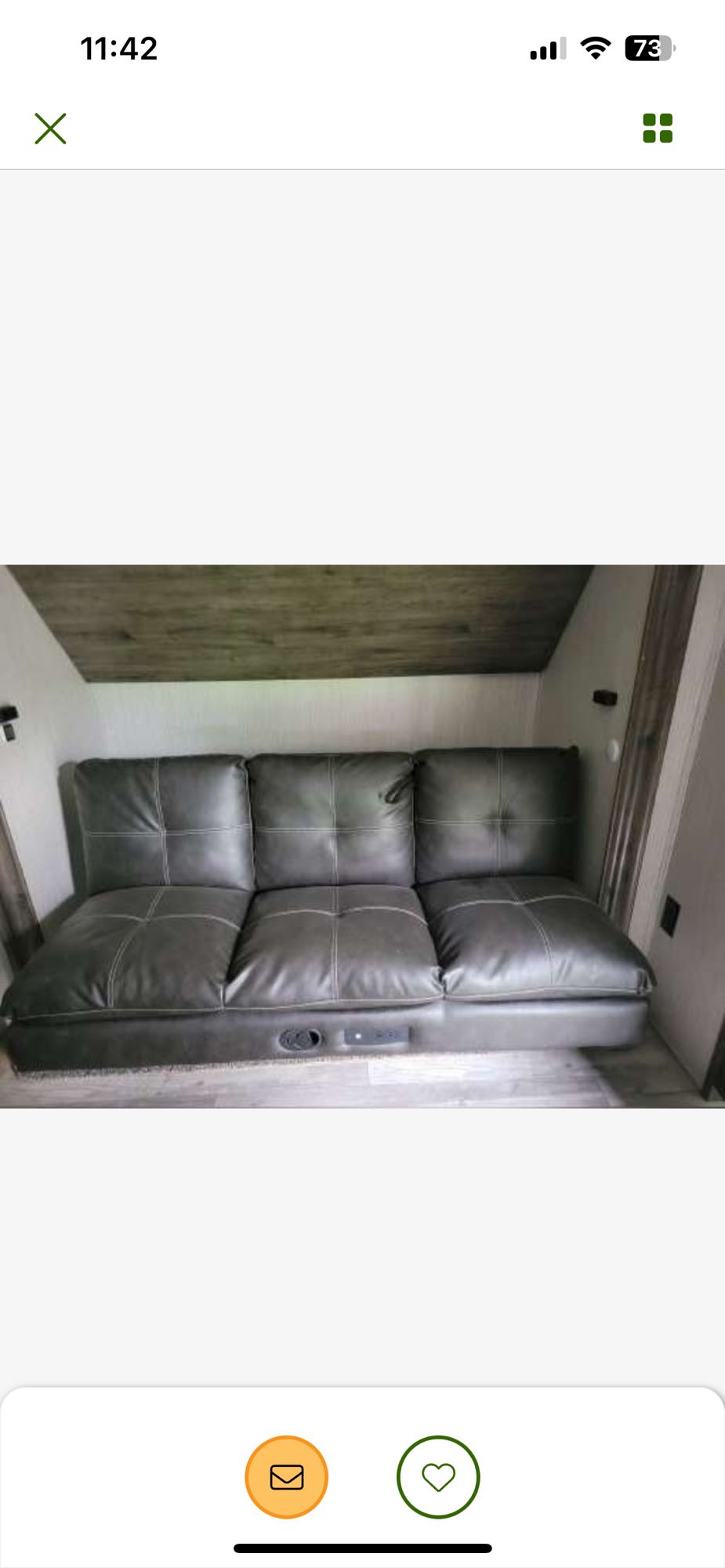 Stylish gray RV sofa with power ports and cupholder, perfect for your next rv rental. Cozy, compact interior.. Forest River Sierra 2021