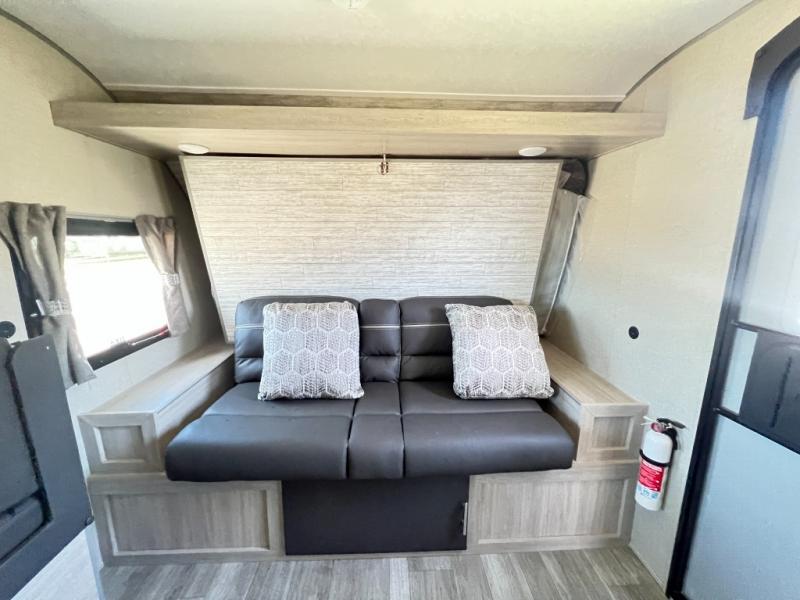 Cozy RV rental living space with a comfy sofa (likely converts to bed), overhead storage, and a fire extinguisher for safety.. Forest River Coachmen Catalina Summit 2022