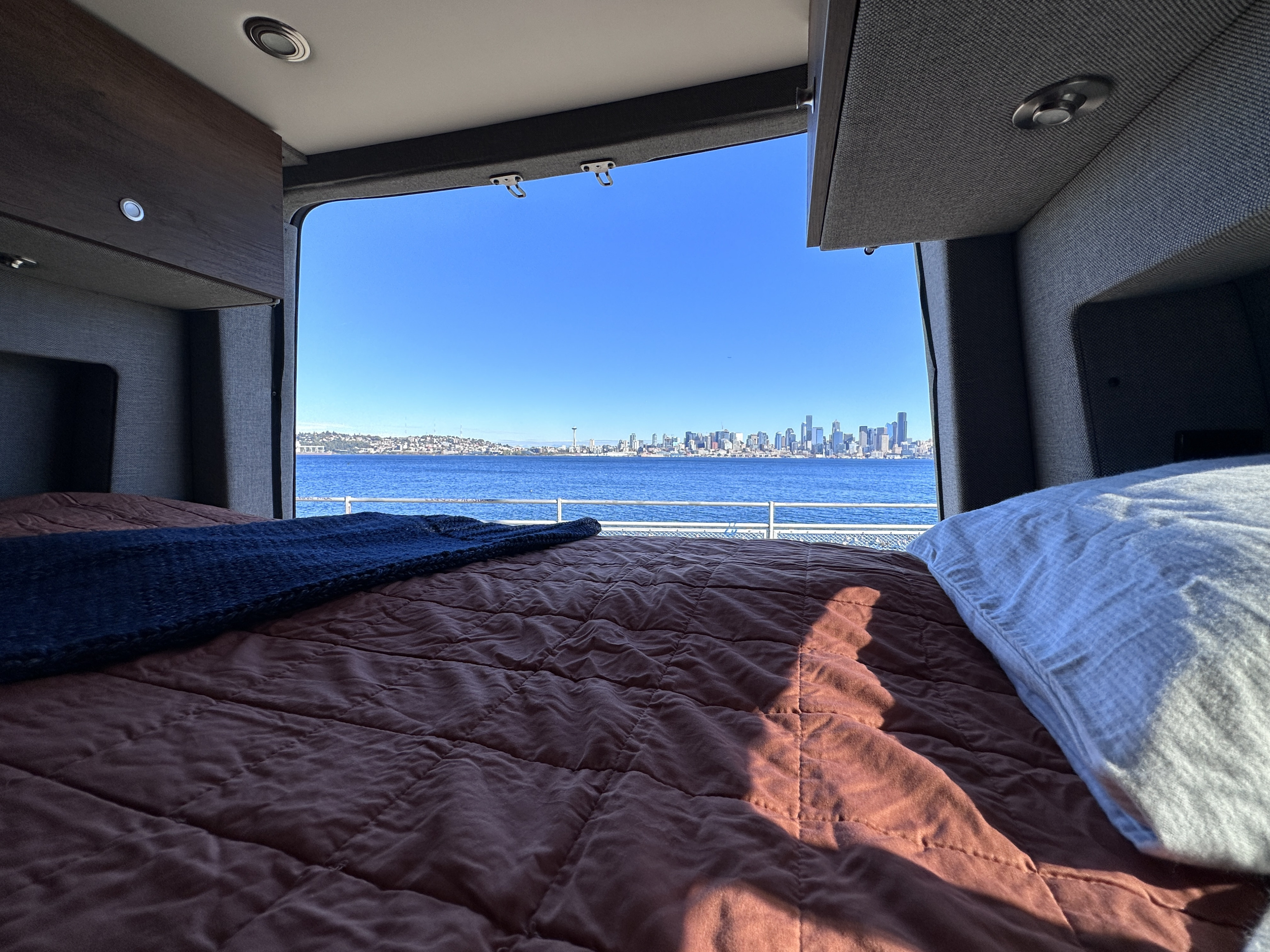 Wake up to stunning Seattle waterfront views from your cozy RV rental bed. Perfect for scenic travel!. Storyteller Overland Storyteller Overland Class B 2020