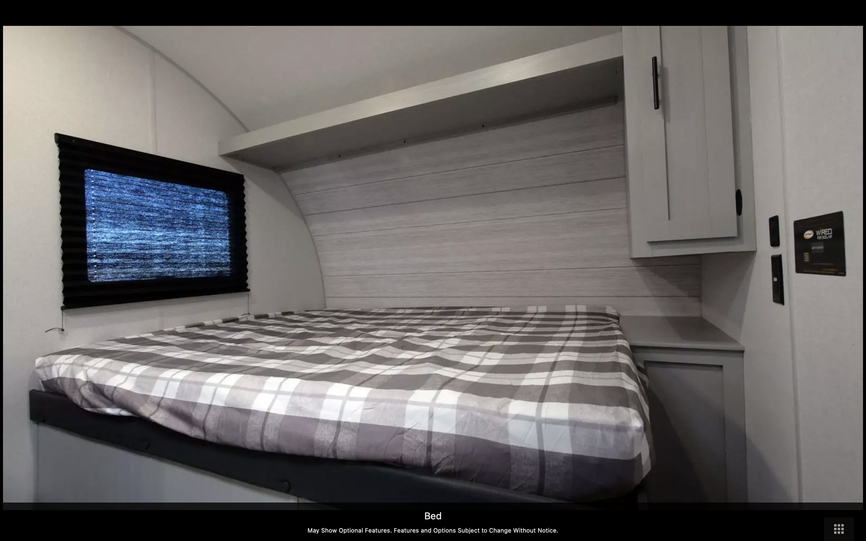 Cozy RV rental bedroom with a comfy plaid bed and storage, ideal for your next adventure.. Forest River Wildwood FSX 2023