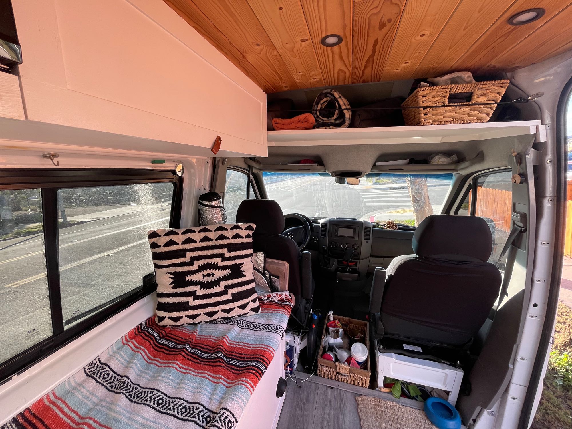 Cozy RV rental camper van interior. Features custom wood ceiling, overhead storage, and comfy bench/bed. Ready for adventure!. Mercedes Sprinter 2011