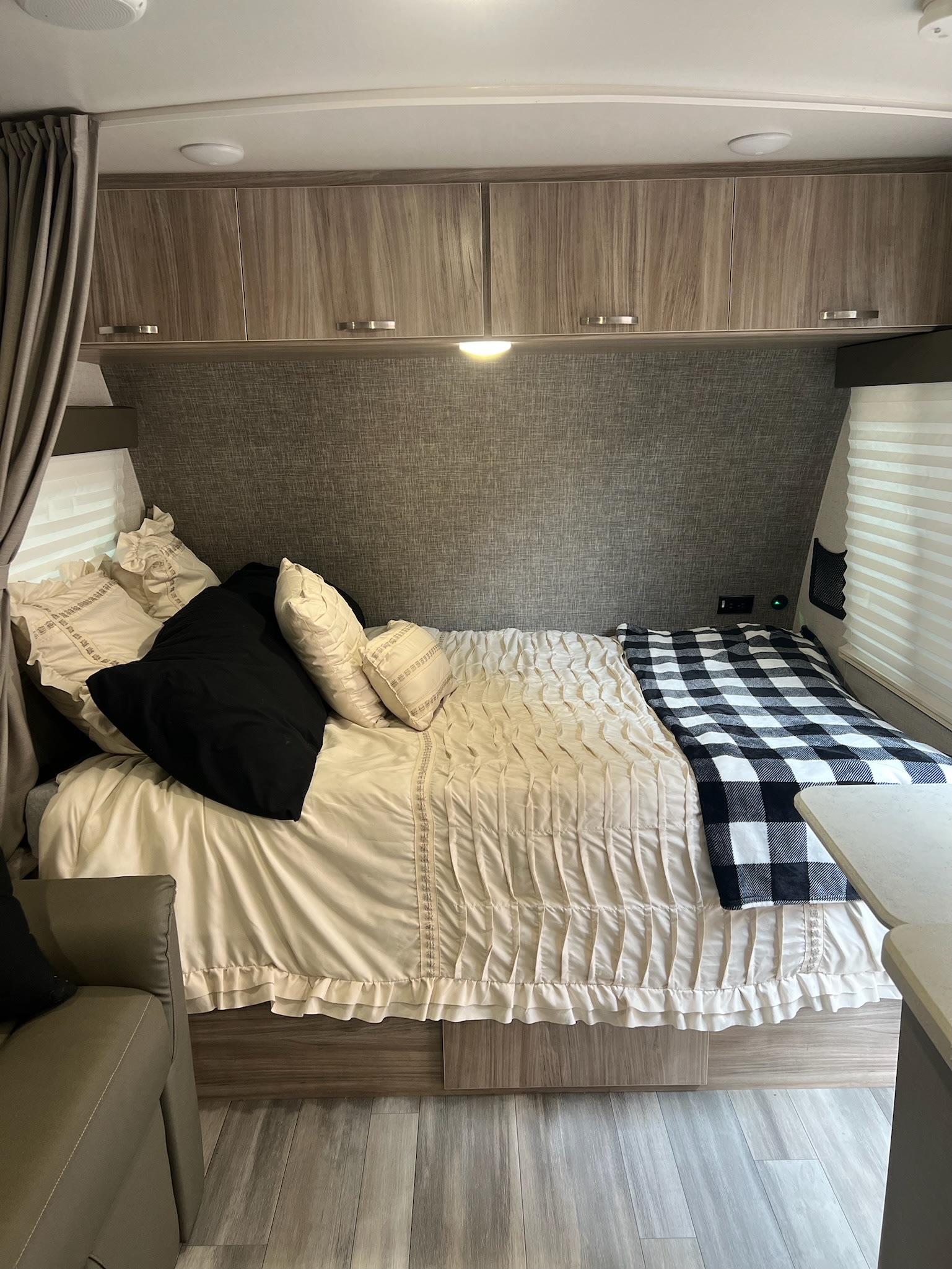 Cozy RV rental bedroom with comfortable bedding and overhead storage, perfect for your next road trip.. Winnebago Minnie Winnie 2022