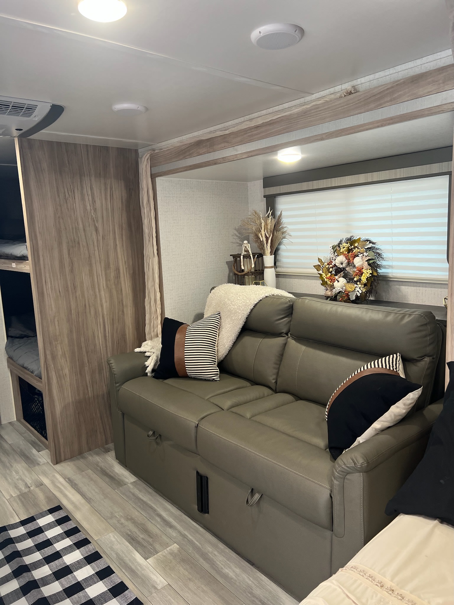 Modern rv rental interior with a comfy sofa, bunk beds, and cozy fall decor, ready for family adventures.. Winnebago Minnie Winnie 2022