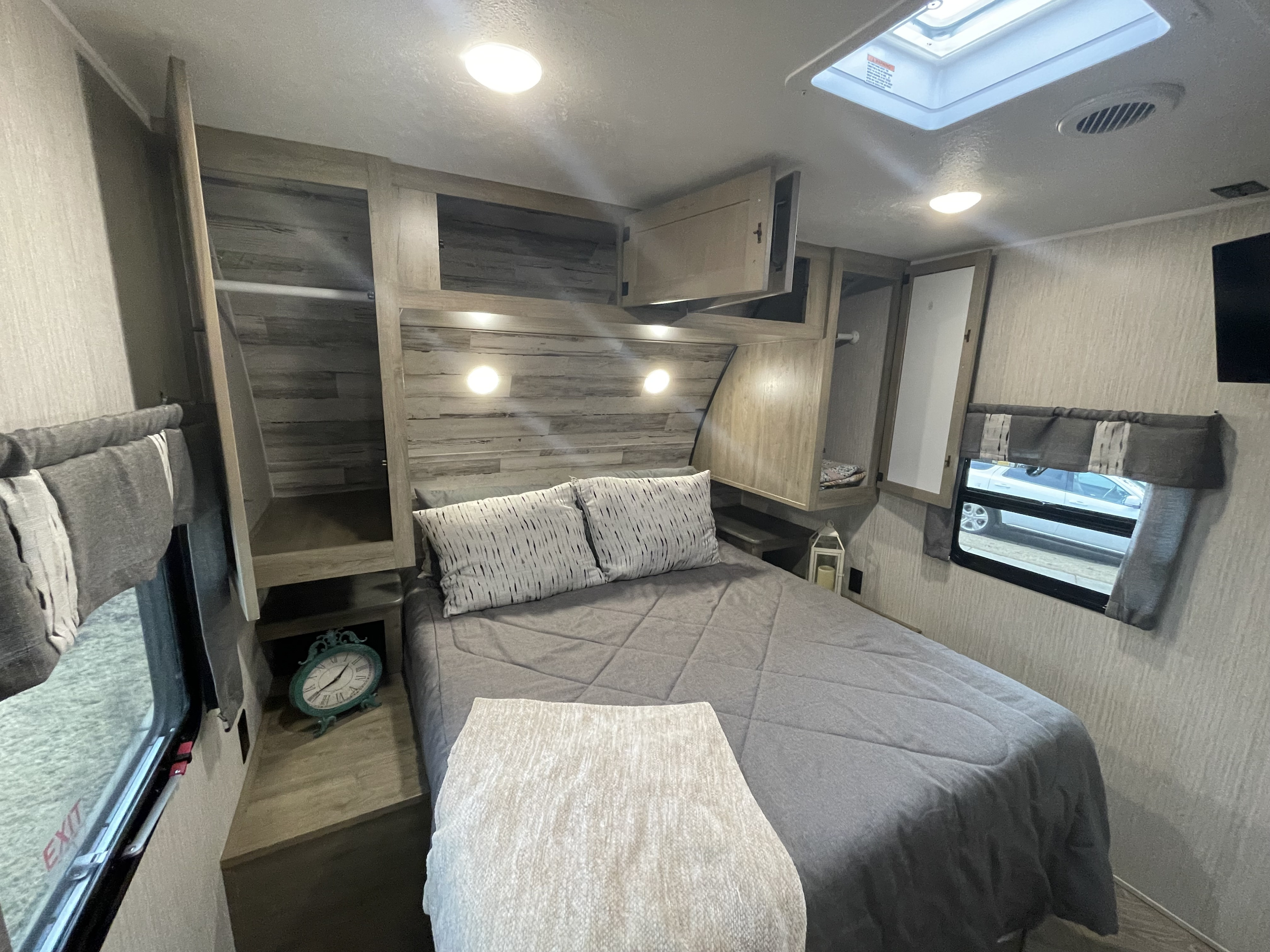 Comfortable RV rental bedroom with ample storage, a queen bed, skylight, and inviting decor, perfect for mobile adventures.. Forest River Palomino Puma 2023