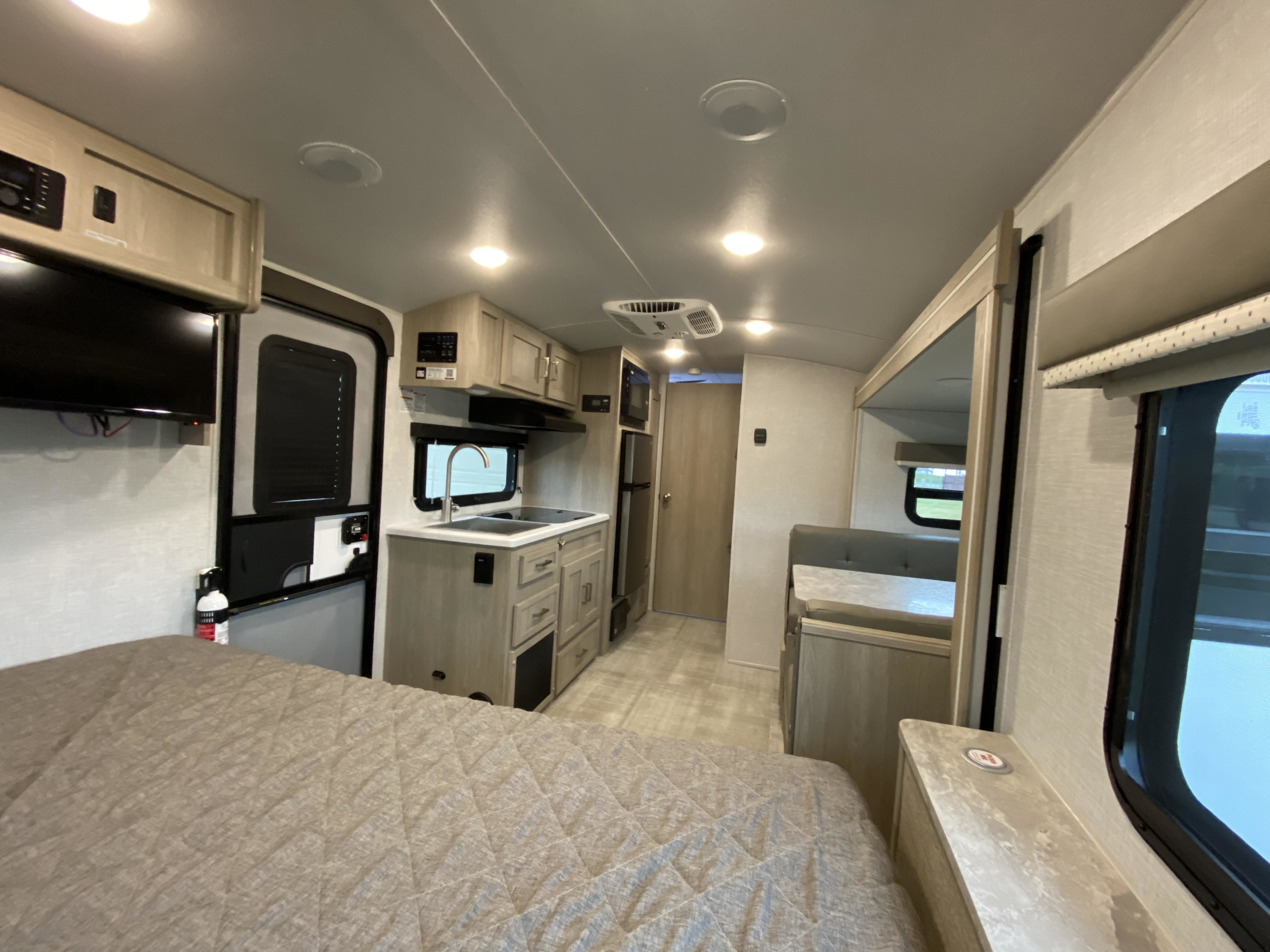 This RV rental interior features a comfortable bed, full kitchen, and dinette, offering a complete home-like travel experience.. Forest River Rockwood Geo Pro 2023