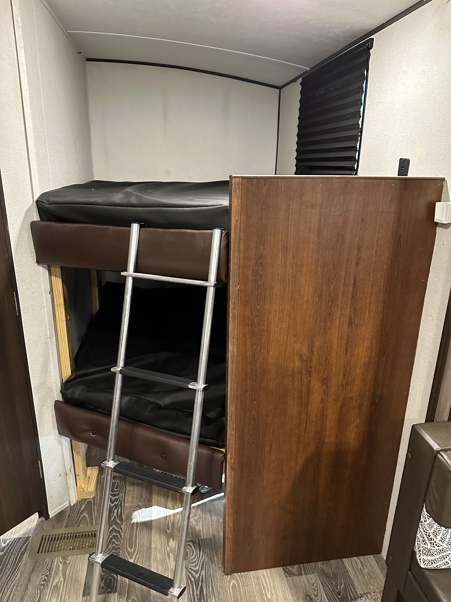 RV rental bunk beds: features two bunks with black mattresses, brown padded frames, and a metal ladder.. Keystone RV Springdale 2020