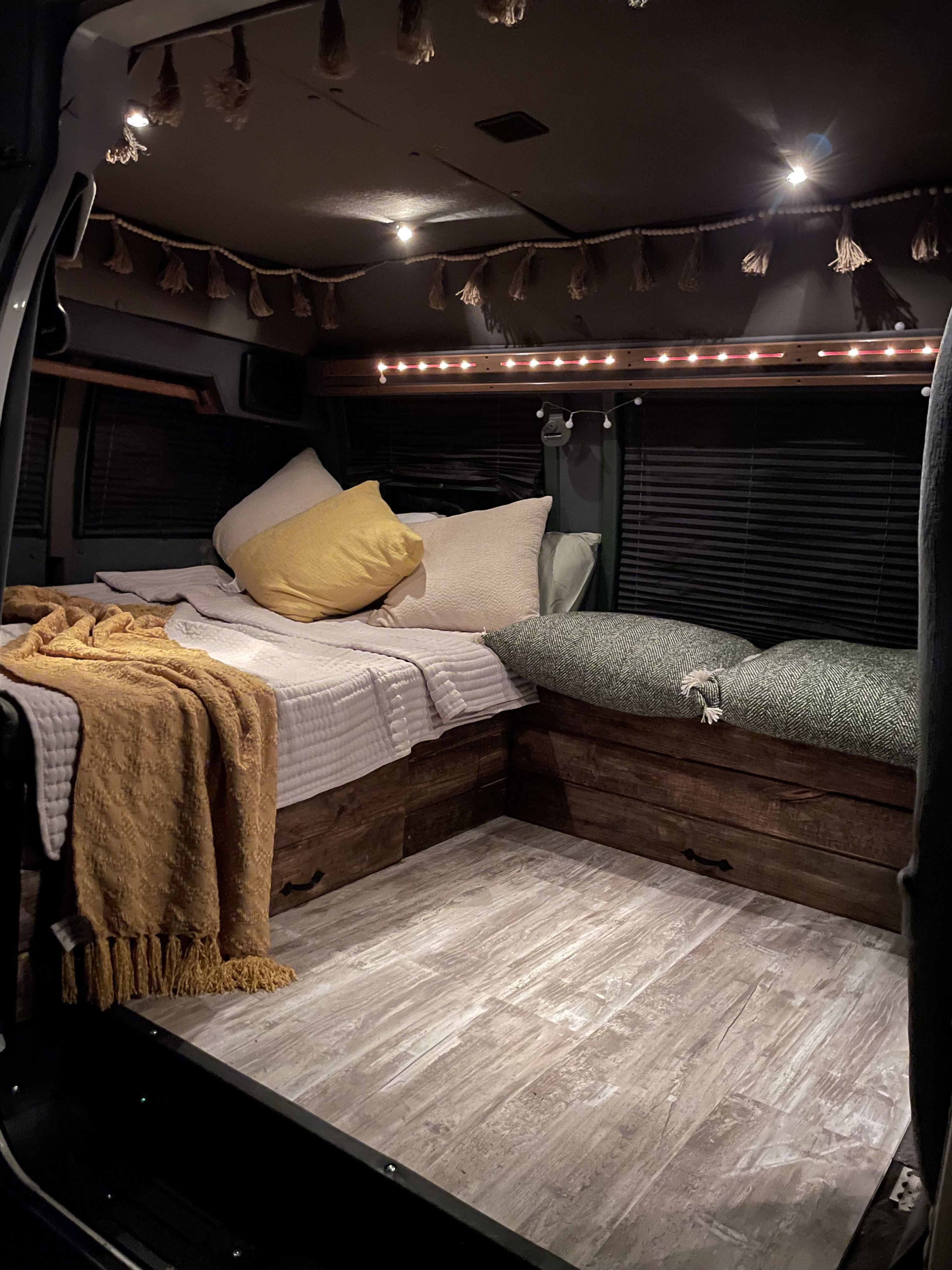 Enjoy this cozy RV rental's inviting interior with a comfortable bed, warm blankets, and ambient lighting.. Dodge Sprinter 2500 170ext 1997