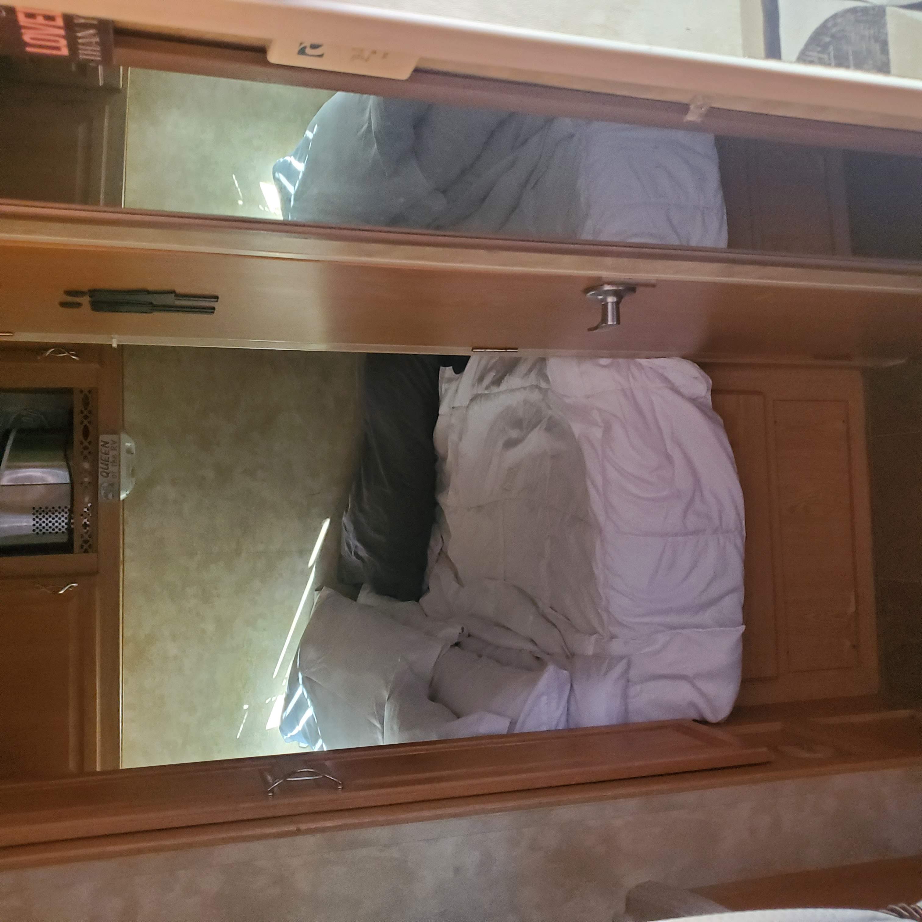 An RV rental's organized interior, featuring upper and lower bunk beds with clean bedding. Perfect for families.. Fleetwood Gearbox 2007