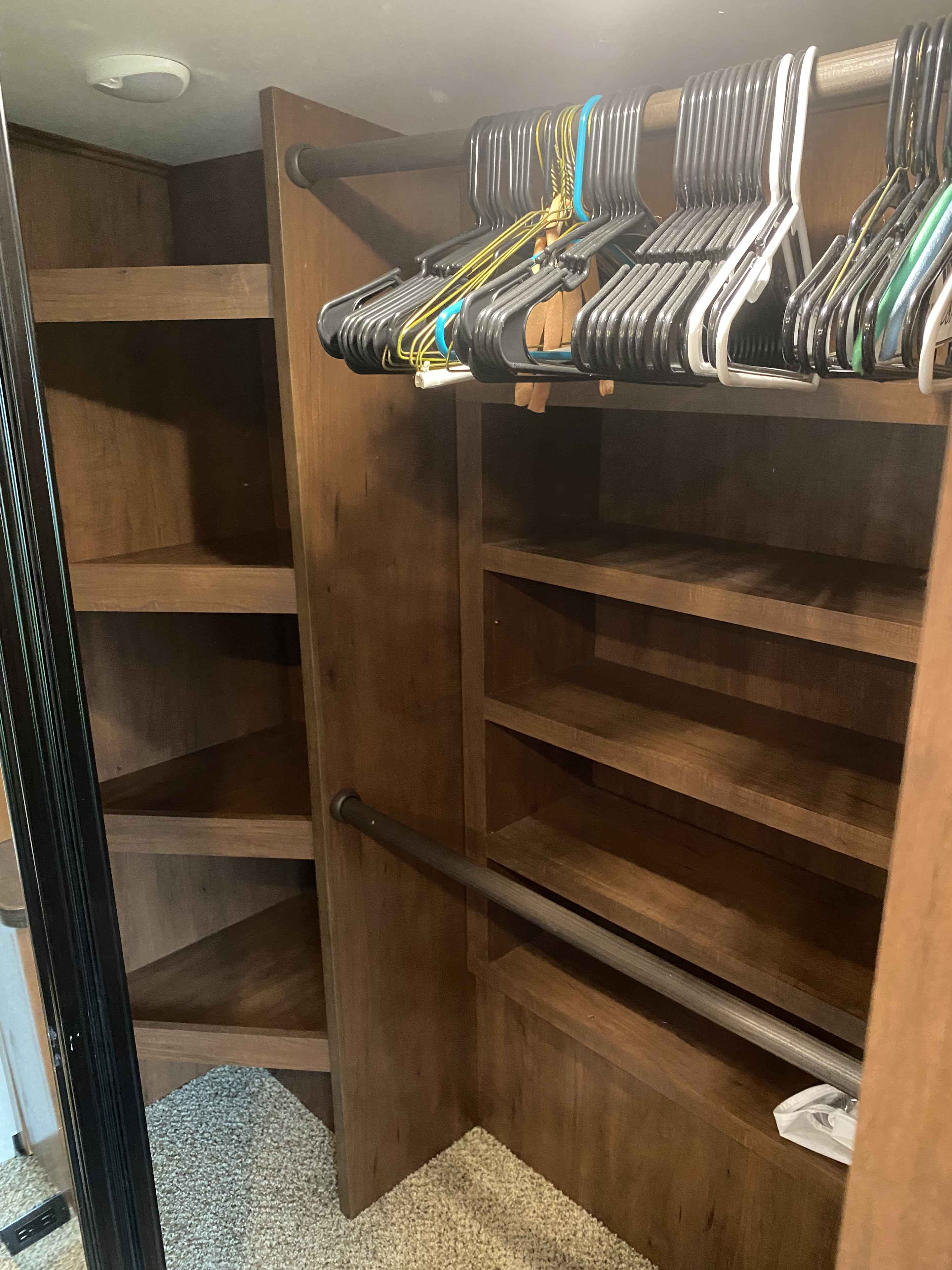 Spacious RV rental closet featuring multiple shelves, two hanging rods, and a collection of hangers, providing ample storage.. Jayco North Point 2017