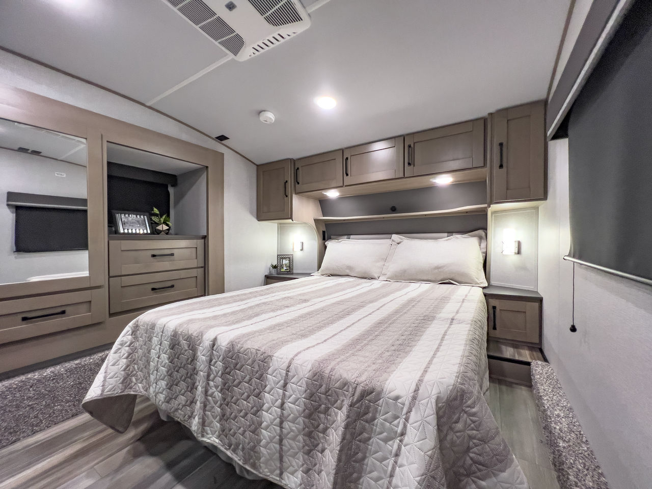 Cozy RV rental bedroom featuring a queen bed, modern cabinetry, and ample storage for comfortable travel.. Grand Design Reflection 2020