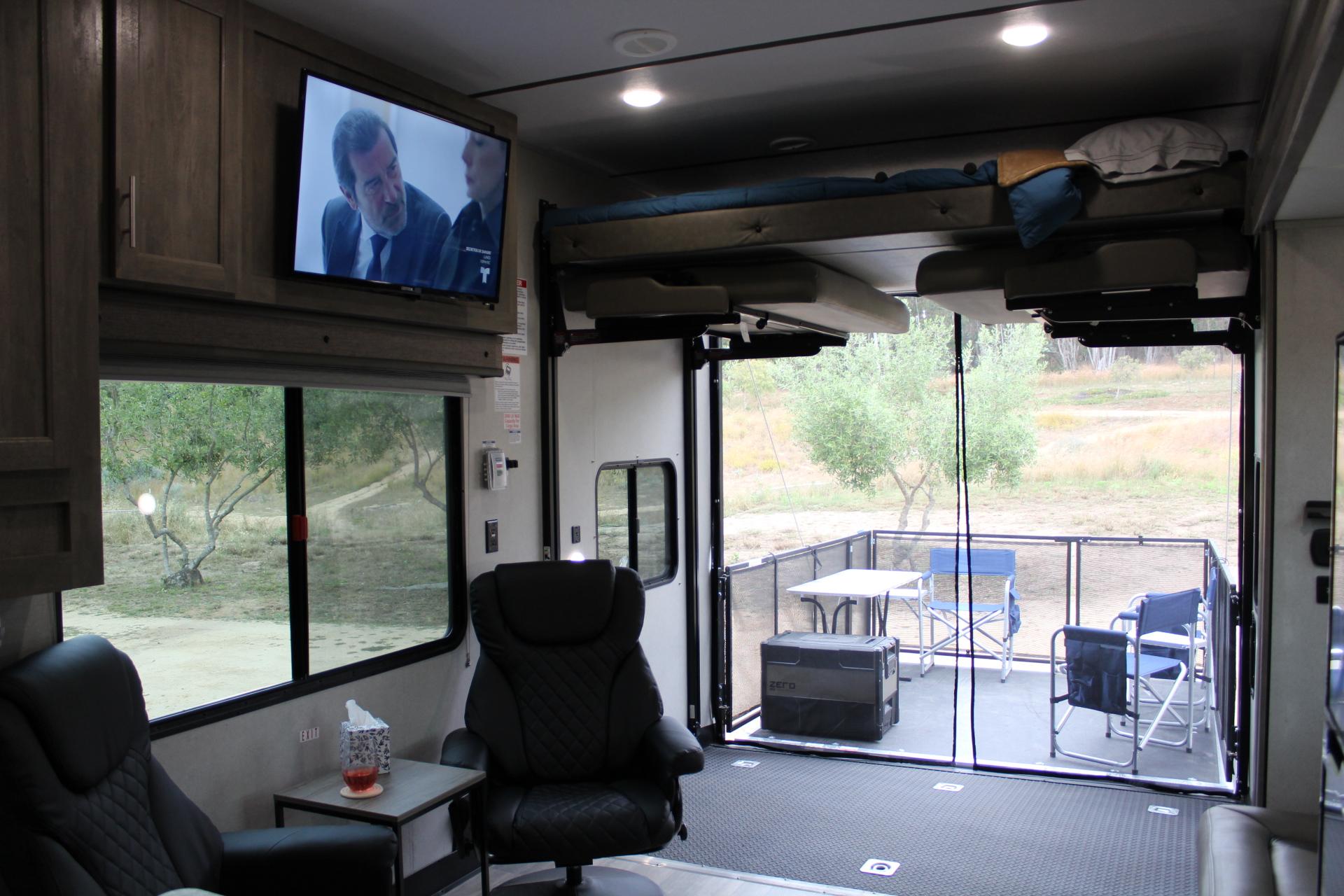 This RV rental offers a comfortable interior with a TV and bunk bed, opening to a spacious ramp patio for outdoor living.. Forest River XLR Boost Toy Hauler 2021