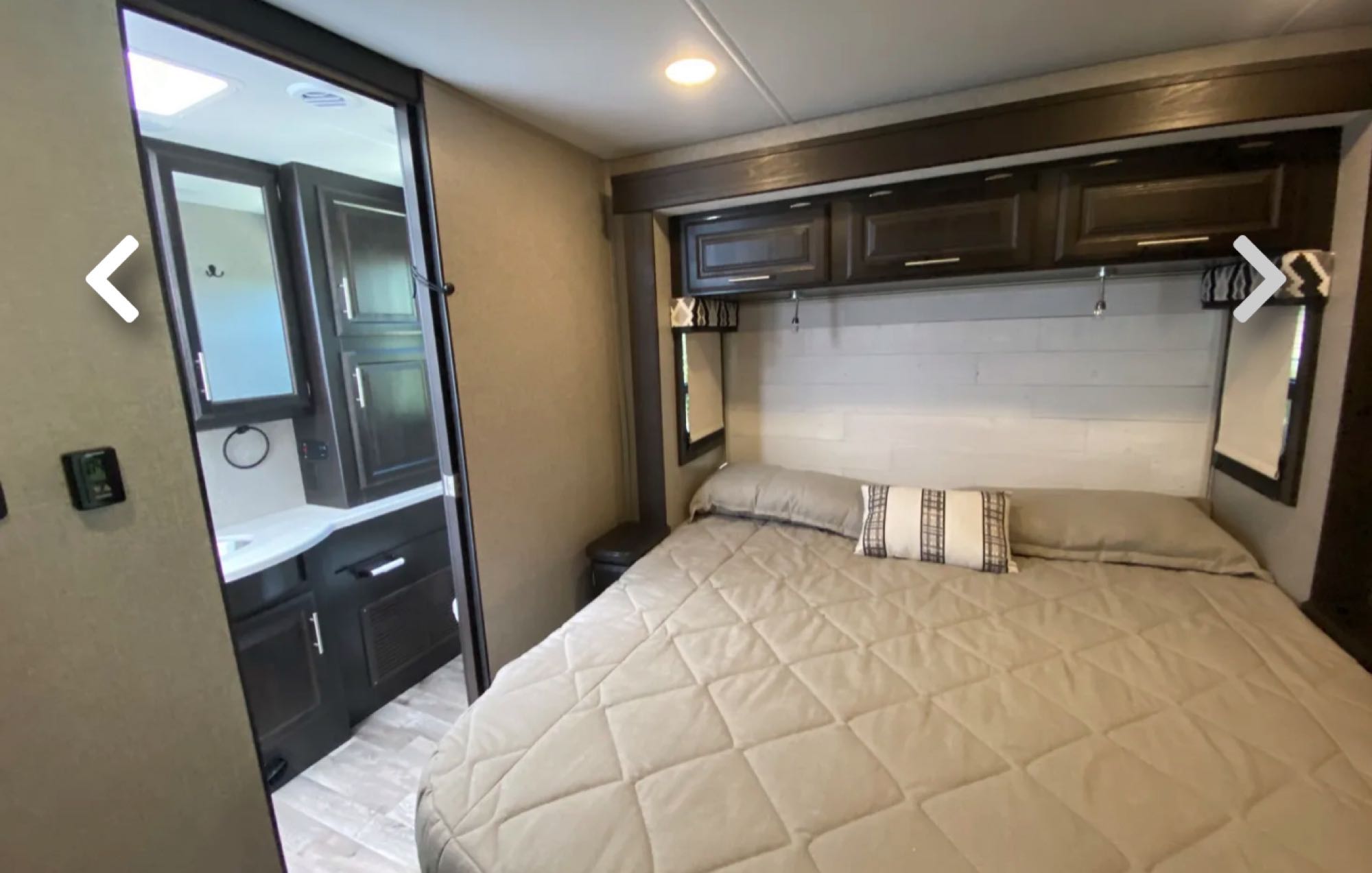 RV rental: Comfy bedroom with queen bed, overhead storage, and an en-suite bathroom with vanity and mirror.. Jayco Precept 2021
