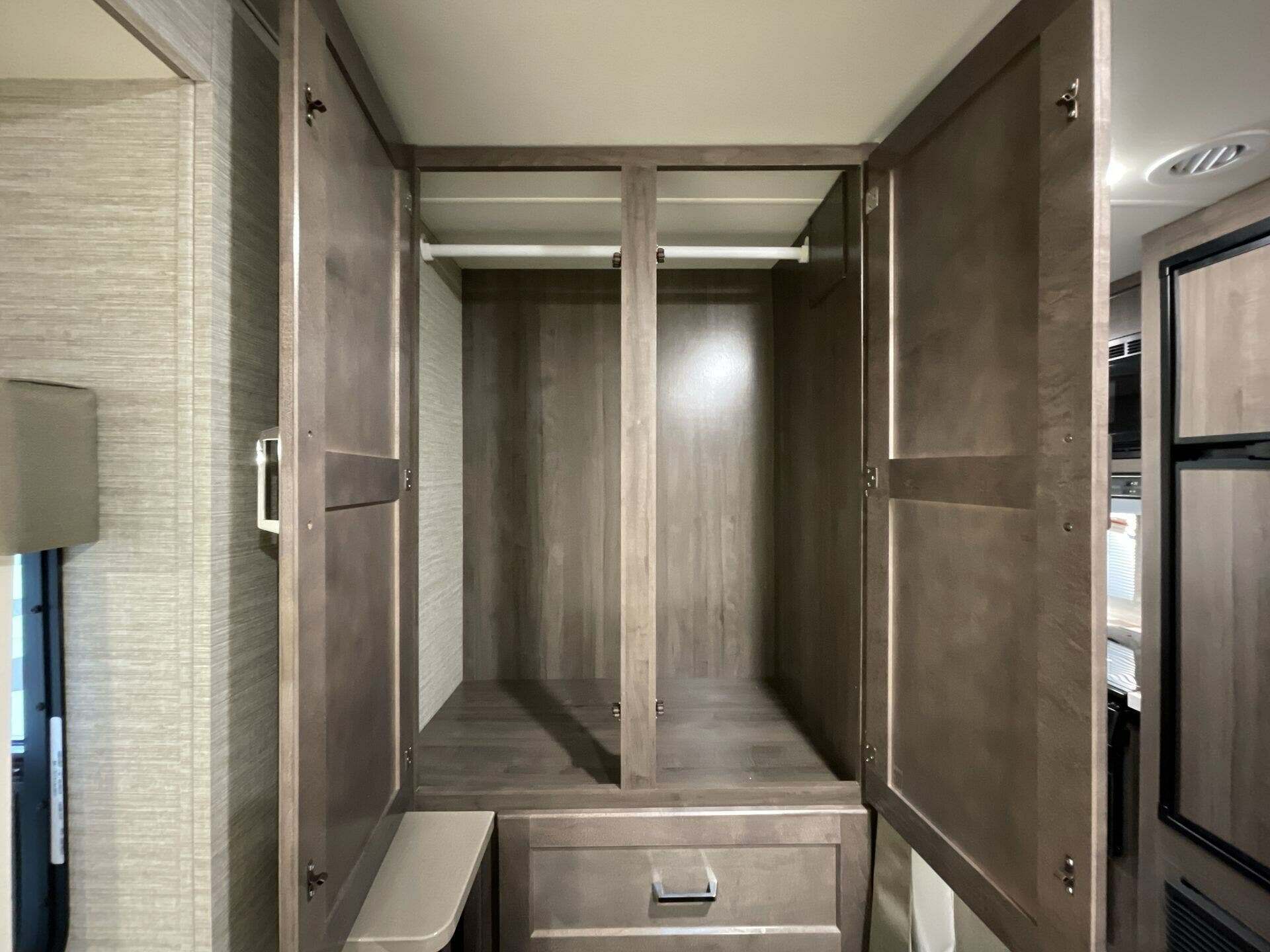 Spacious RV rental wardrobe with hanging rod, drawer, and extra shelving, offering ample storage in this modern RV interior.. Winnebago Minnie Winnie 22M 2024
