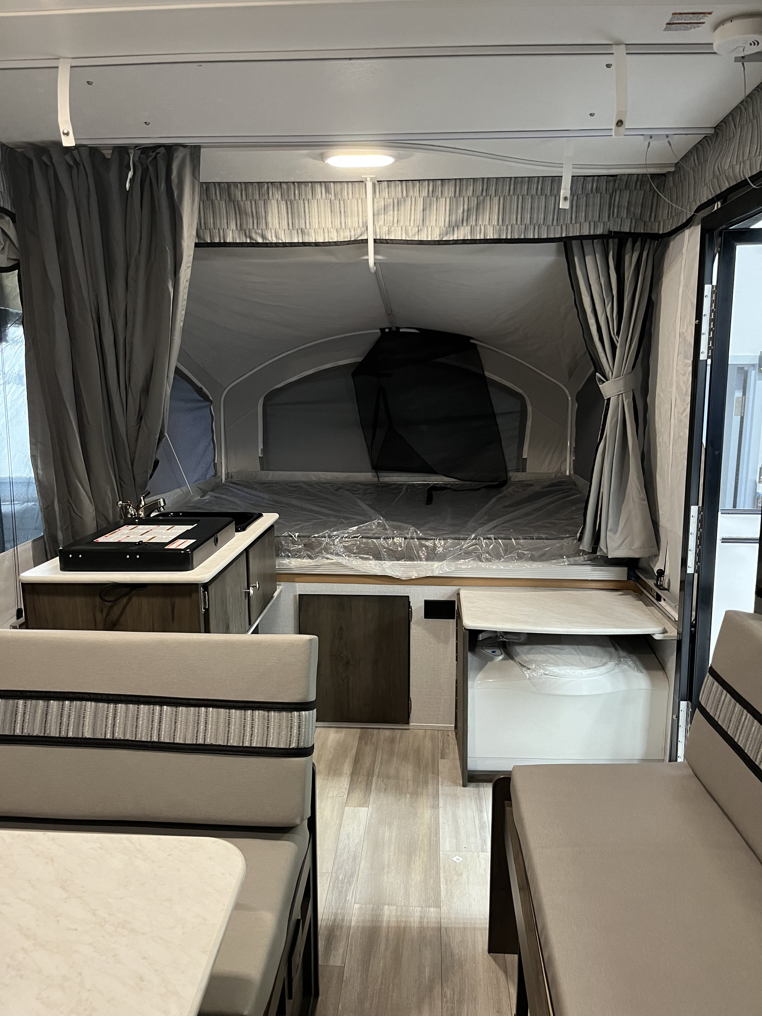 Well-appointed RV rental interior featuring a kitchenette, dining area, and comfortable sleeping space with a portable toilet.. Coachmen Clipper Sport 108ST 2022