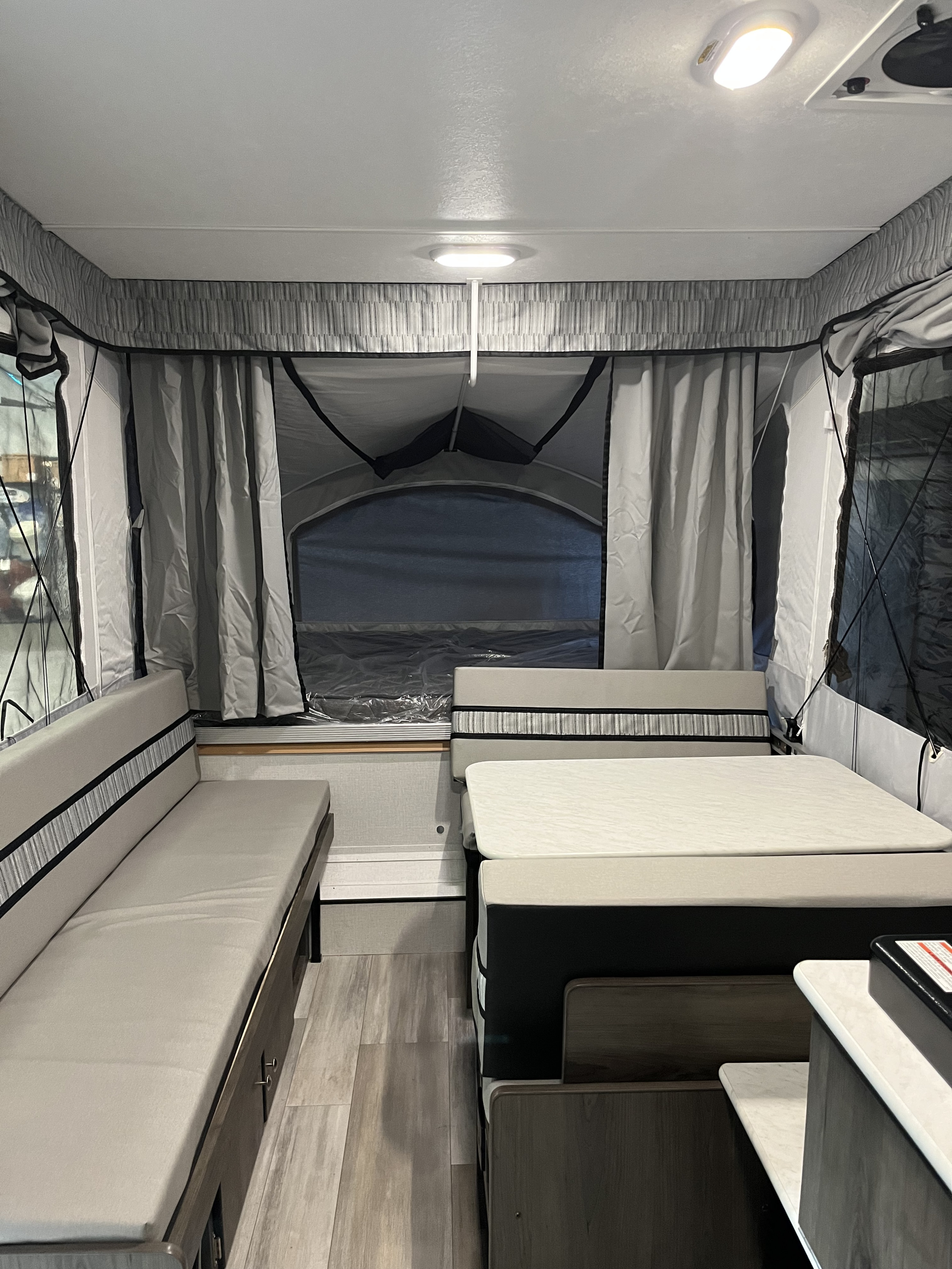 Inside a modern RV rental pop-up camper, showing a cozy dinette and convertible beds for a comfortable trip.. Coachmen Clipper Sport 108ST 2022