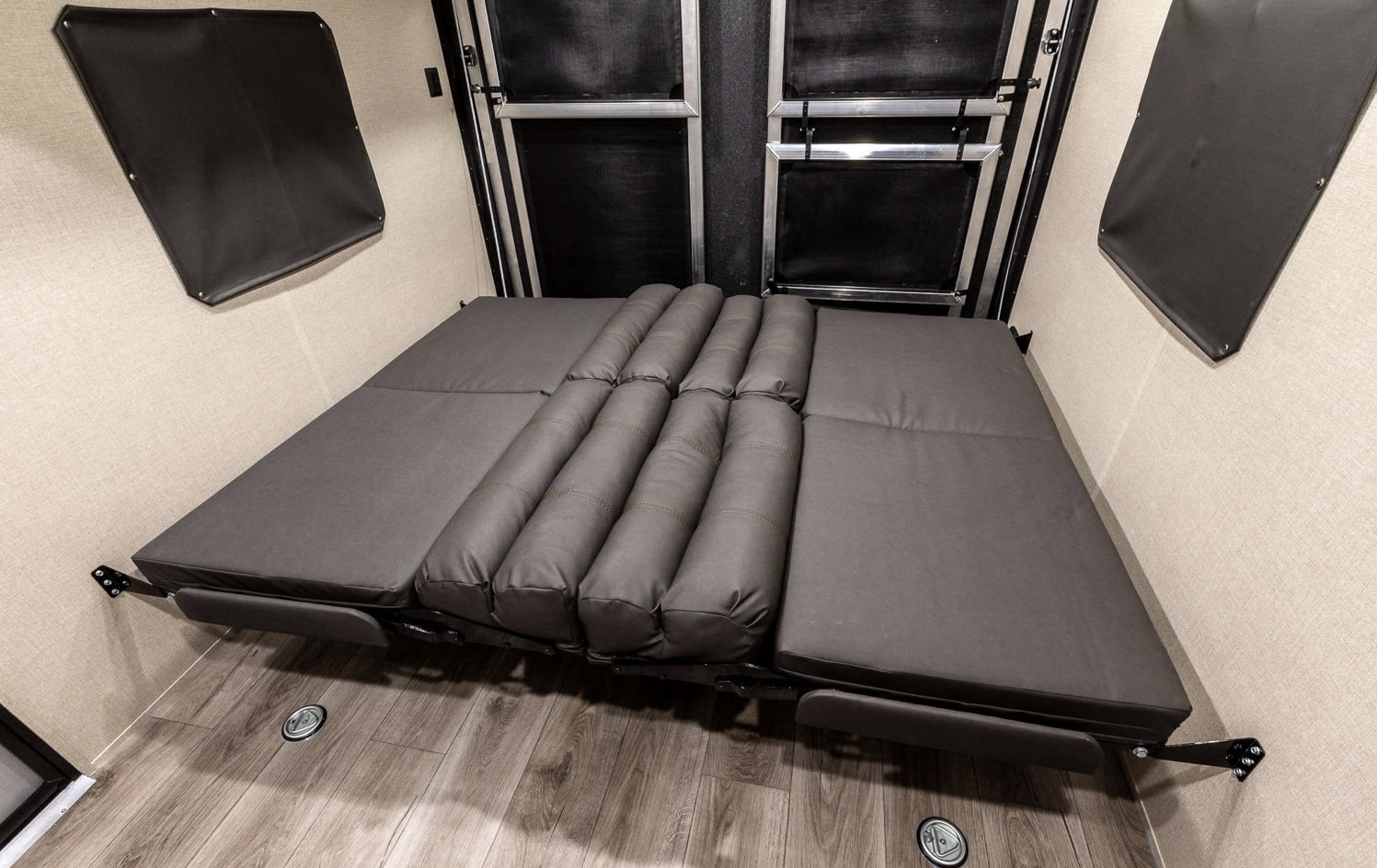 RV rental: Toy hauler interior with a grey convertible bed, offering flexible living and sleeping space.. Coachmen Catalina 2022