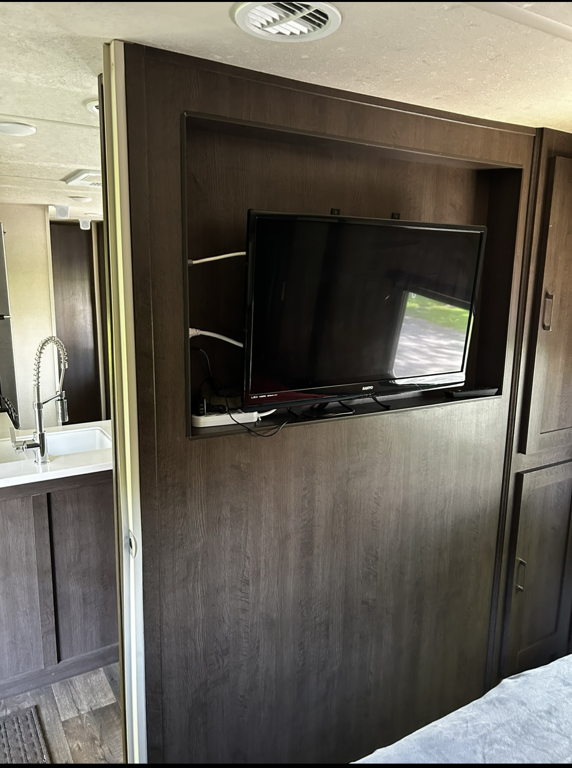 Compact RV rental interior featuring a TV, kitchen sink, and clever storage solutions for comfortable travel.. Forest River Wildwood 2019