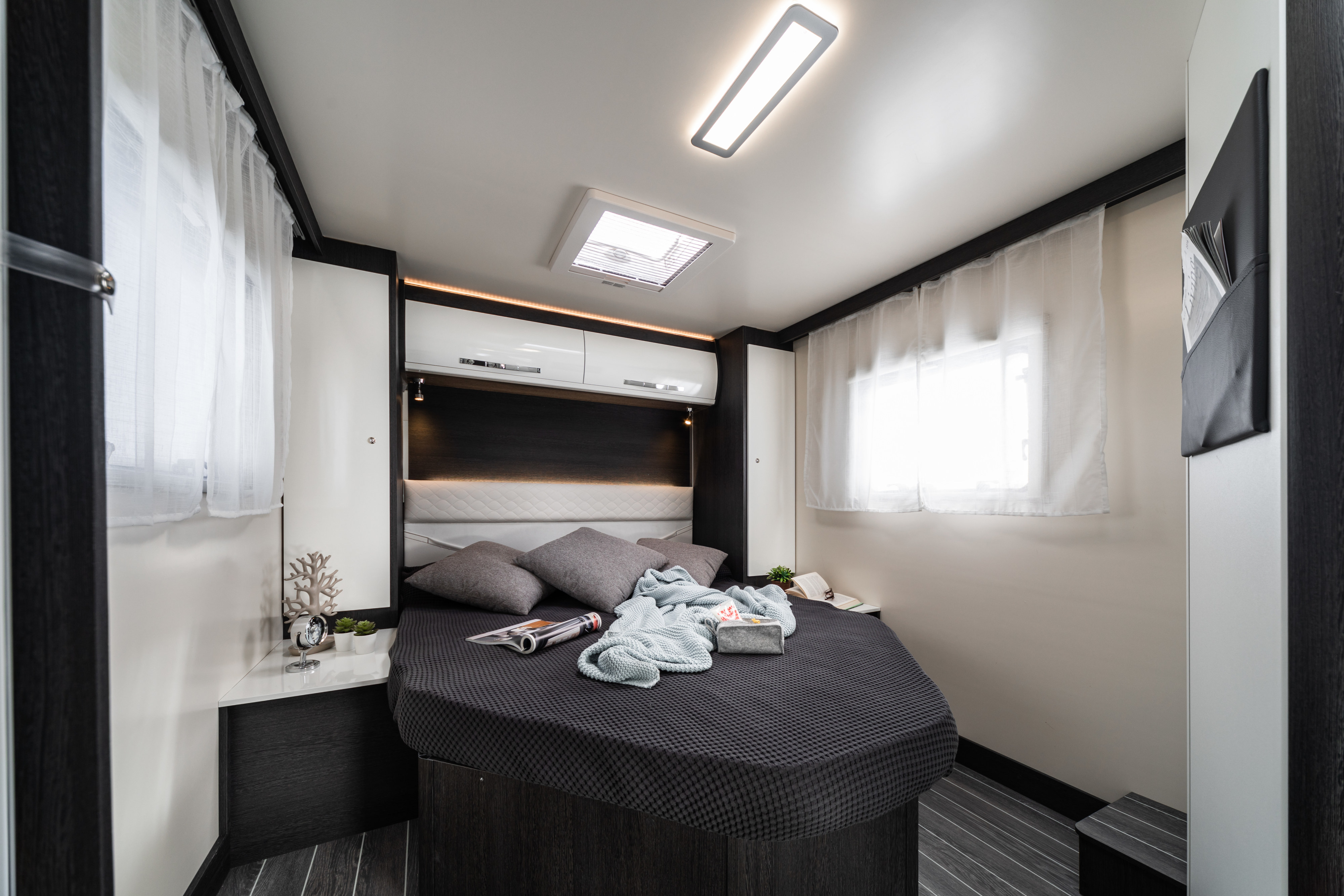 Modern RV rental bedroom with cozy bed, ambient lighting, and storage for comfortable travel.. Rollerteam Zefiro 696 2018