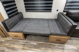 RV rental: Grey upholstered RV dinette bench converted to a bed with storage drawers. Ideal for travel/camping.. Forest River Cherokee Arctic Wolf 2021