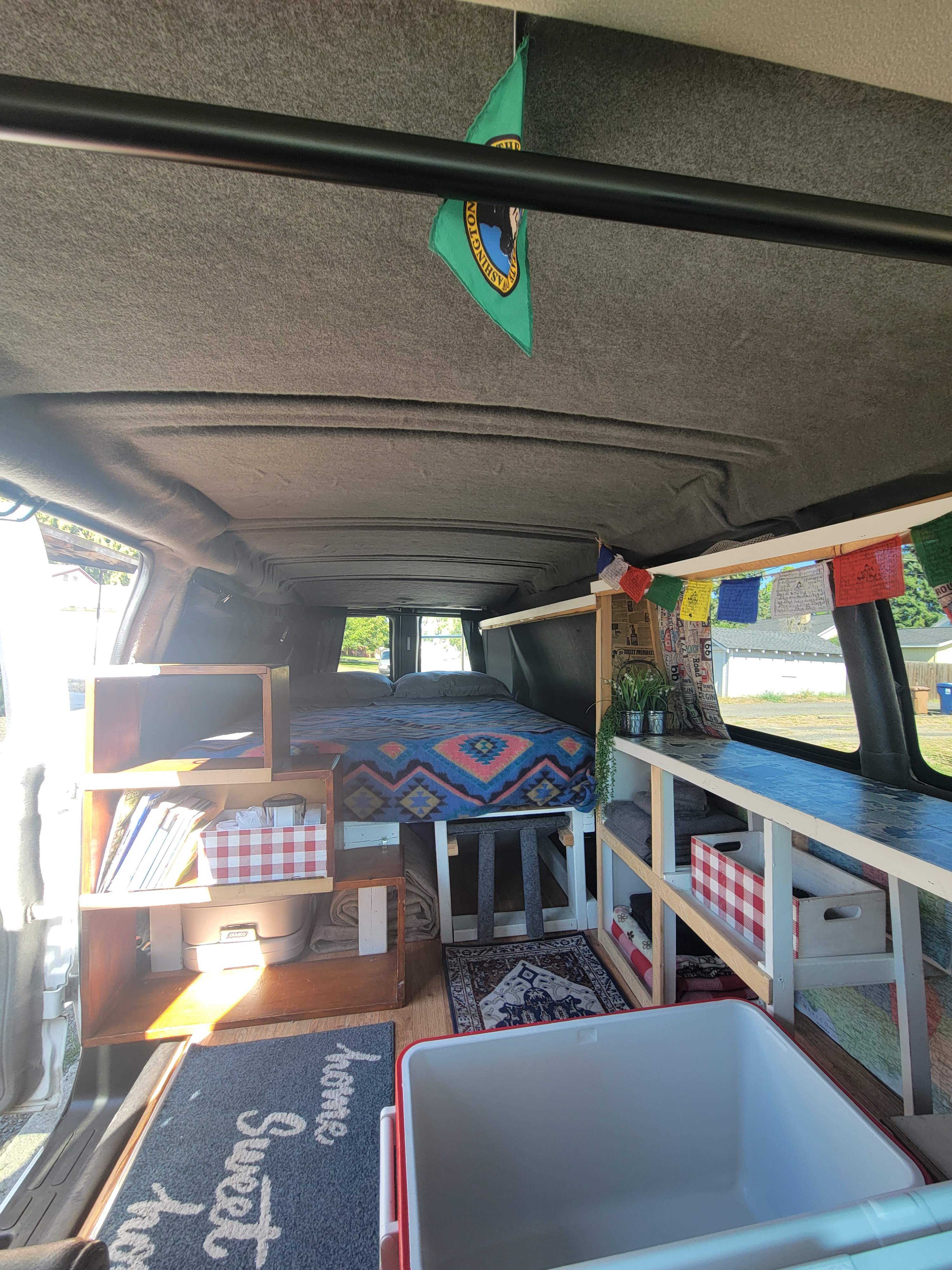 Explore this cozy RV rental van conversion interior with a comfy bed, storage, and compact living area.. Chevrolet 3500 Express 2016