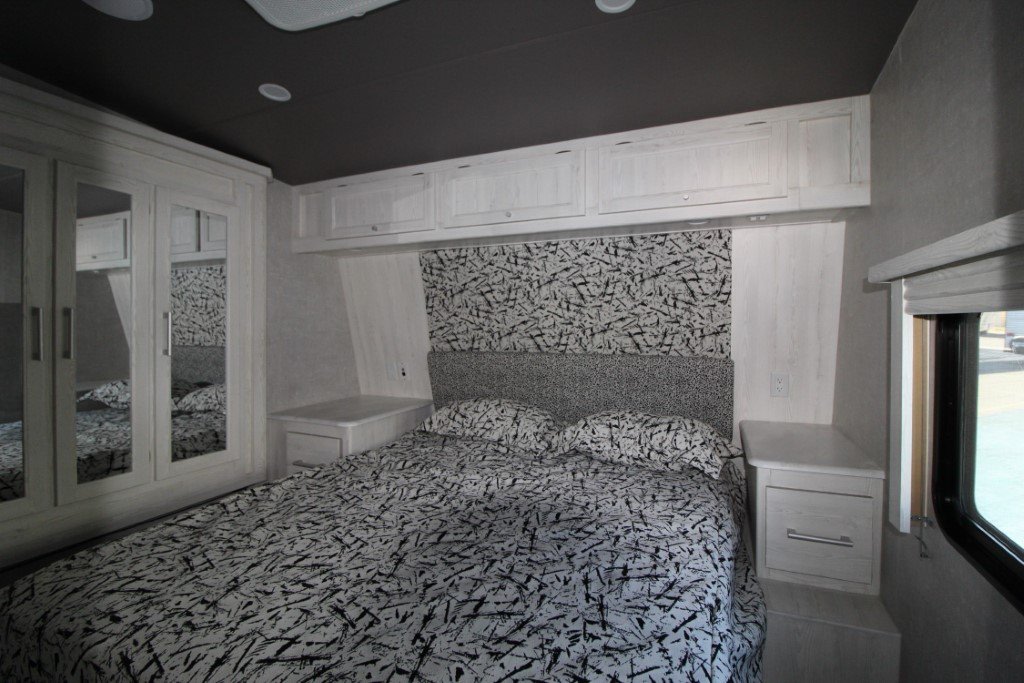 RV rental master bedroom showing white cabinets, mirrored closet, and bold patterned bedding. Comfortably designed for travel.. Eclipse Recreational Vehicles Attitude 2021