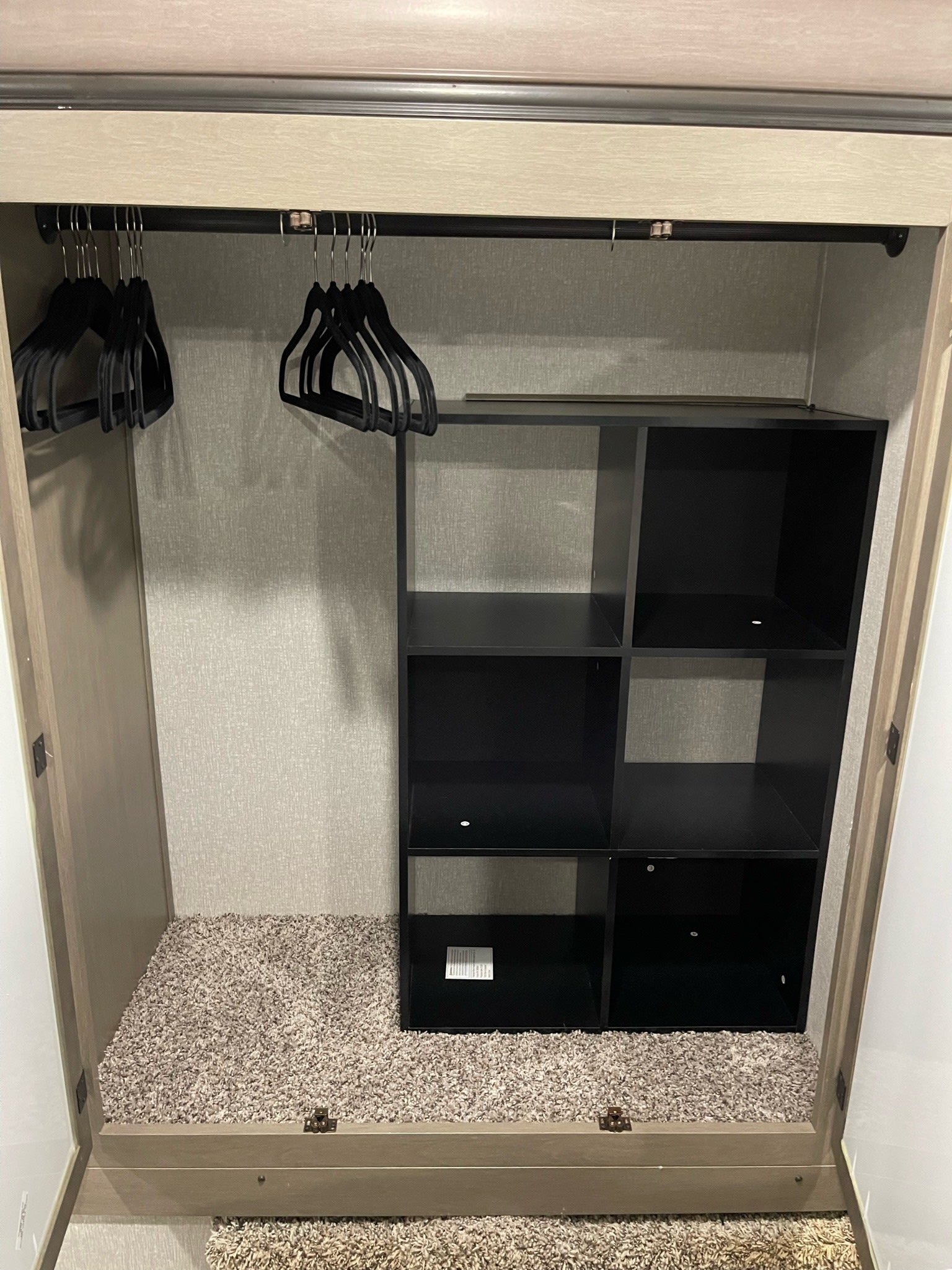 RV rental closet with hanging rod, black velvet hangers, and built-in cubby shelves for organized storage.. Coachmen Chaparral 2021