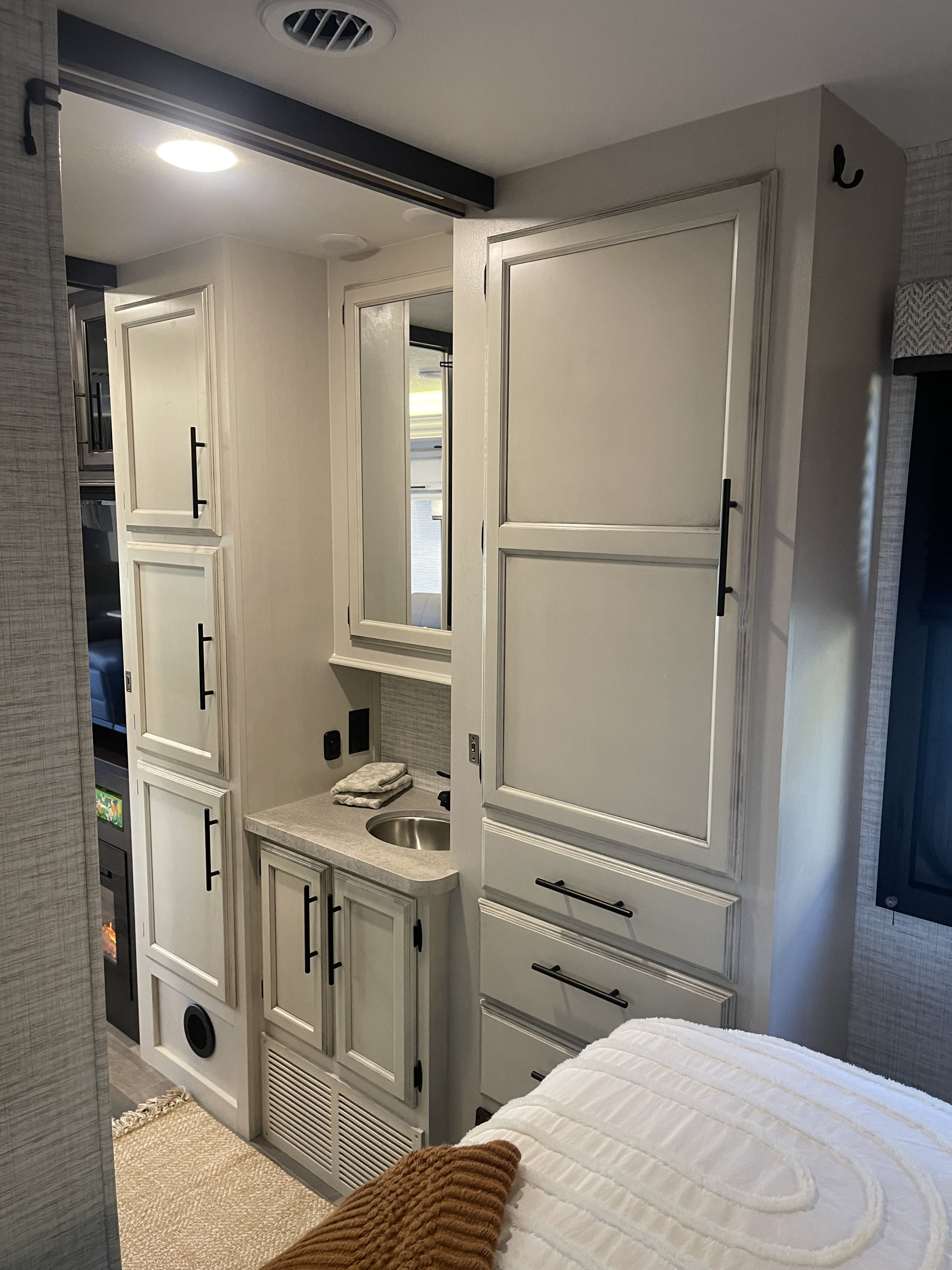 Modern RV rental: a compact interior features light cabinets, a bathroom vanity with sink, and a comfortable bedroom area.. 1fdxe4fn1rdd19855 Entegra Odyssey 2024