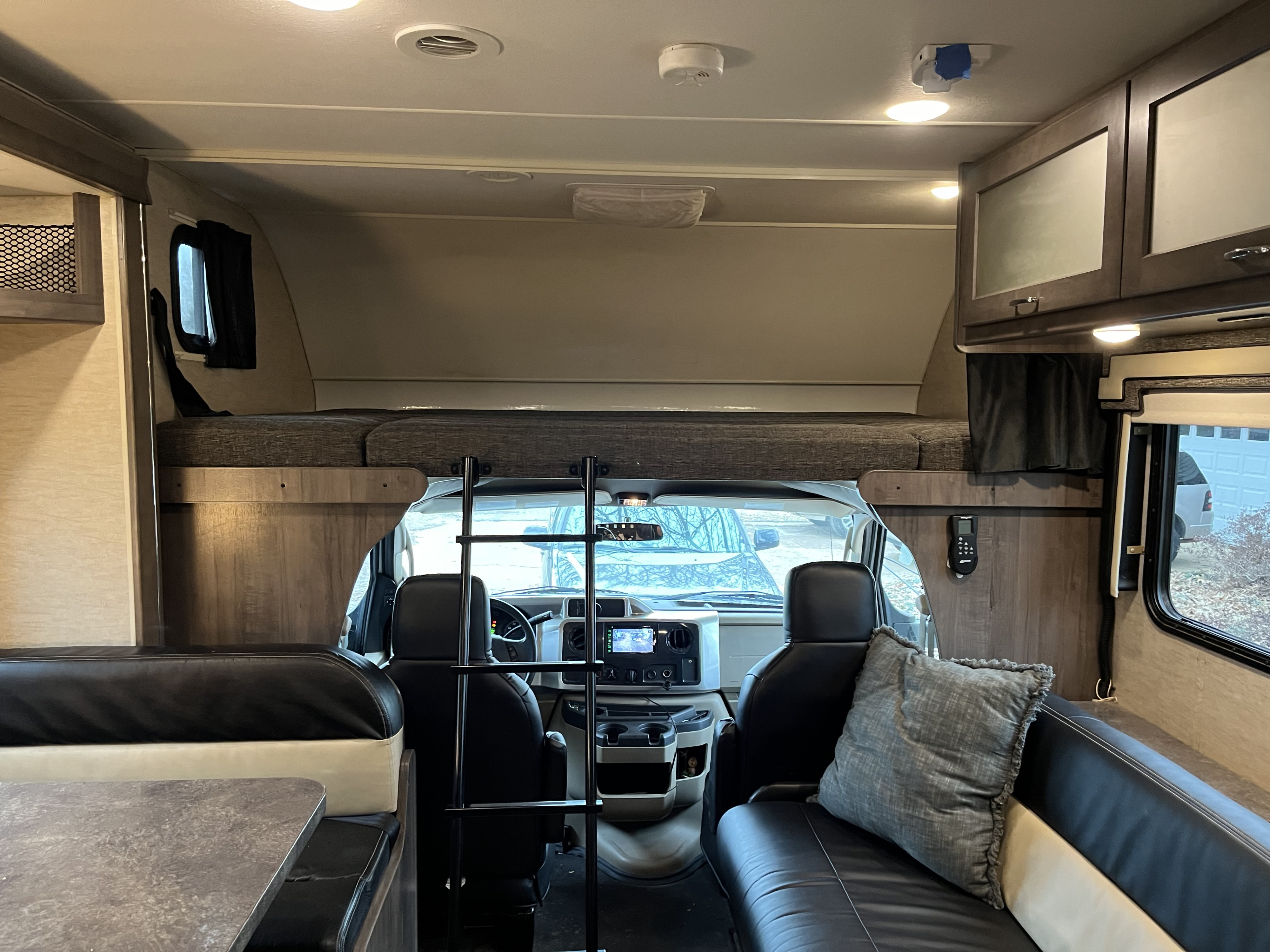 RV rental interior: View from rear shows over-cab bunk, ladder, dinette, sofa, and front driver's area.. Winnebago Spirit 2017