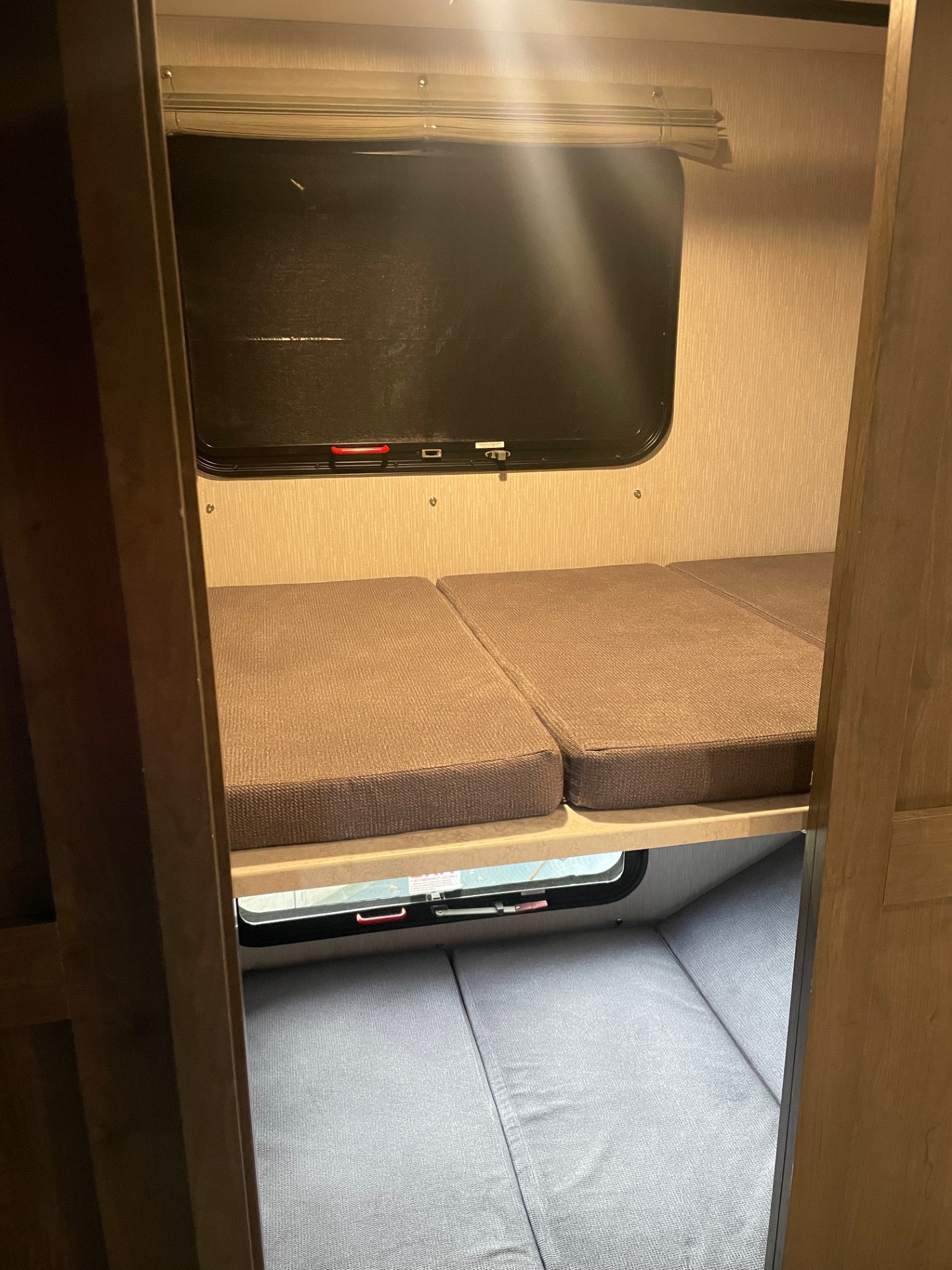 Cozy rv rental bunk beds with brown and gray cushions, featuring windows in a compact camper interior.. Coachmen MIRADA 35ESF 2026