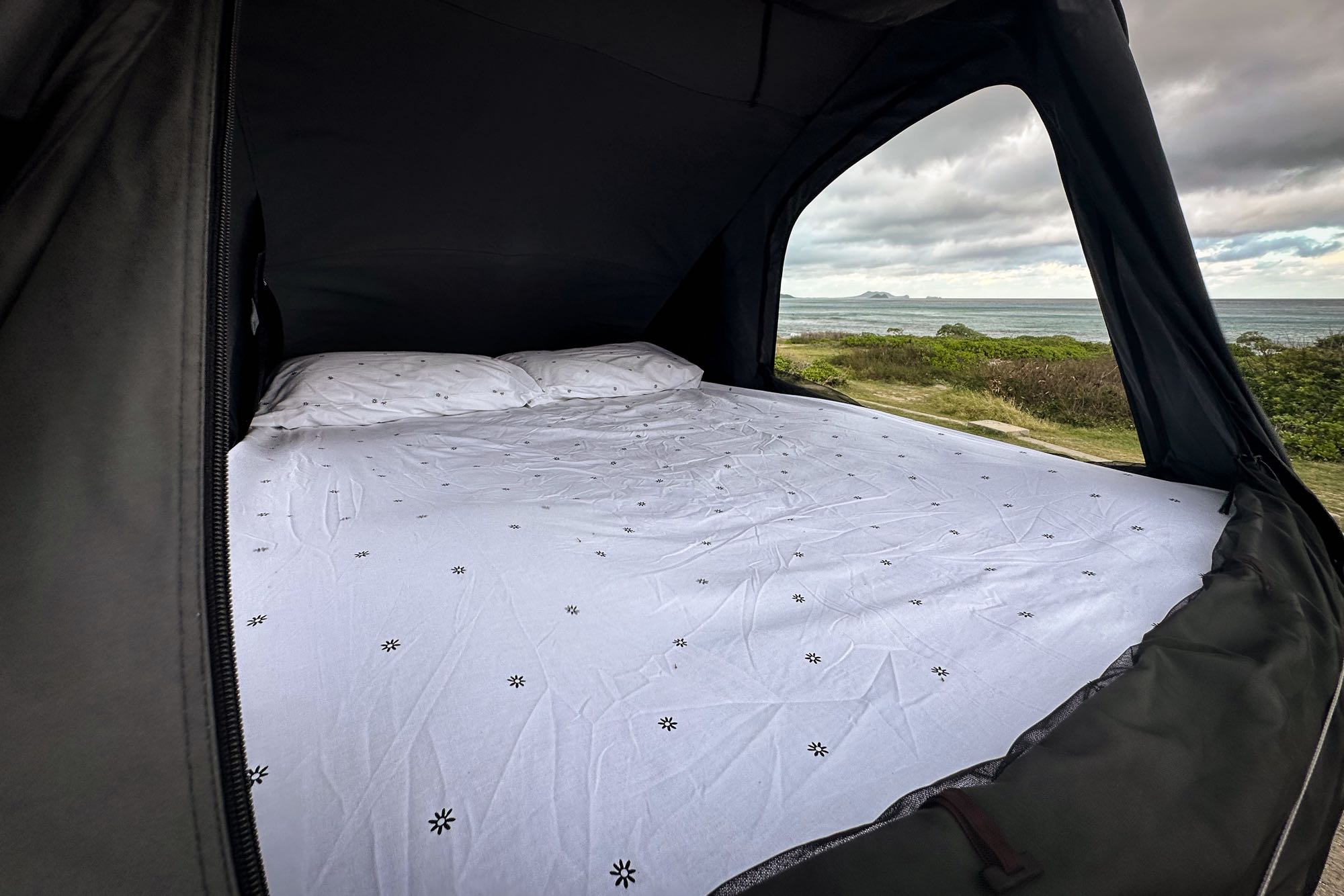 RV rental: Cozy bed in a pop-up tent with a stunning ocean view. Ideal camping setup!. Jeep Gladiator 2022
