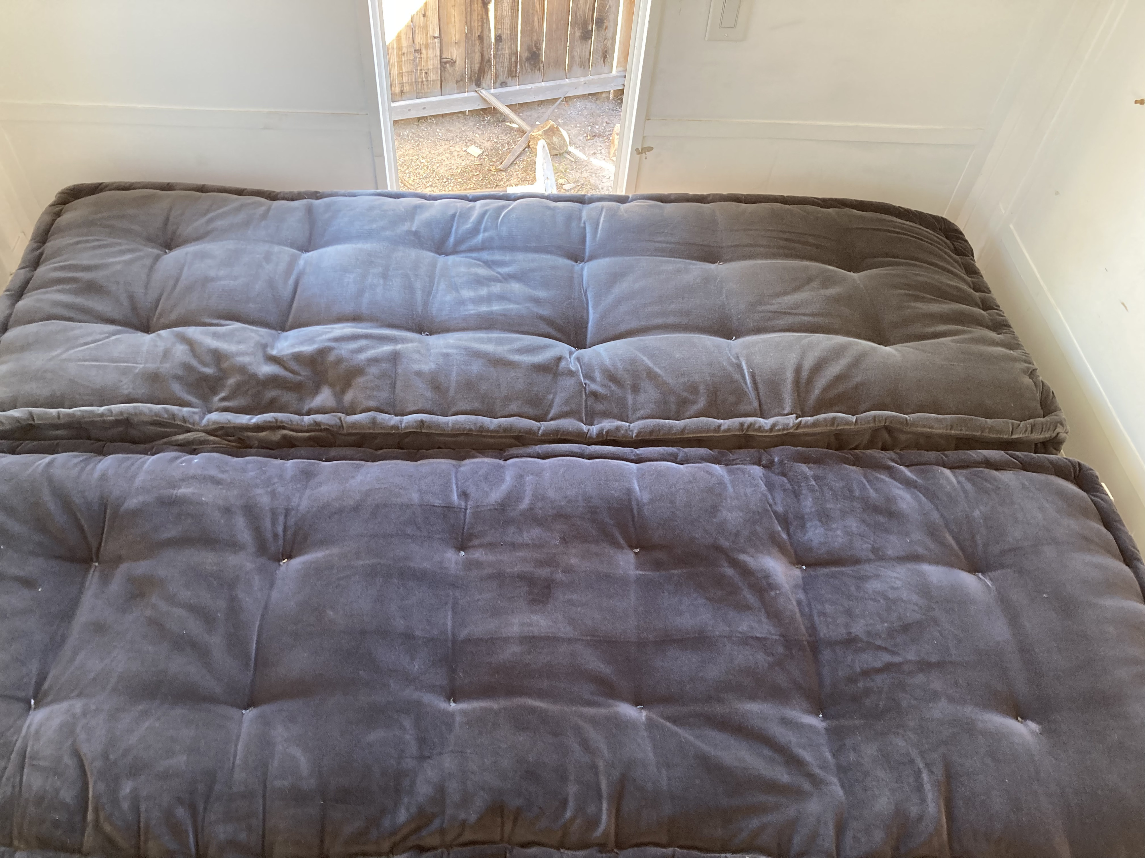 Comfortable dark grey tufted futon cushions in an RV rental, perfect for versatile seating or sleeping inside.. International 3800 1995