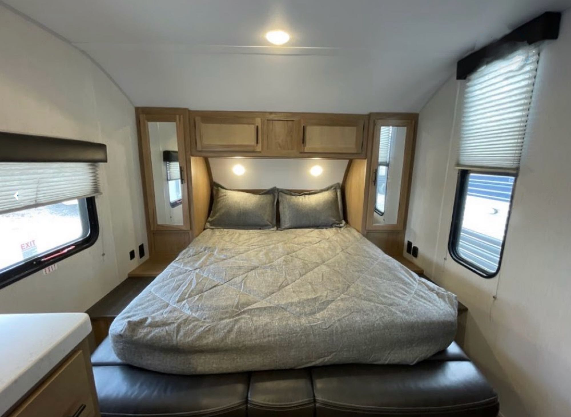 Comfortable RV rental bedroom featuring a queen bed, overhead storage, and windows for natural light.. Forest River Cherokee Grey Wolf Special Edition 2023