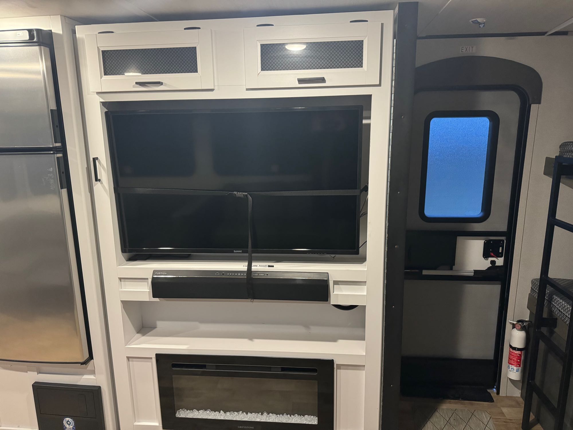 Explore this RV rental's living space: built-in entertainment center with TV, soundbar, fireplace, and refrigerator.. keystone hideout 2022