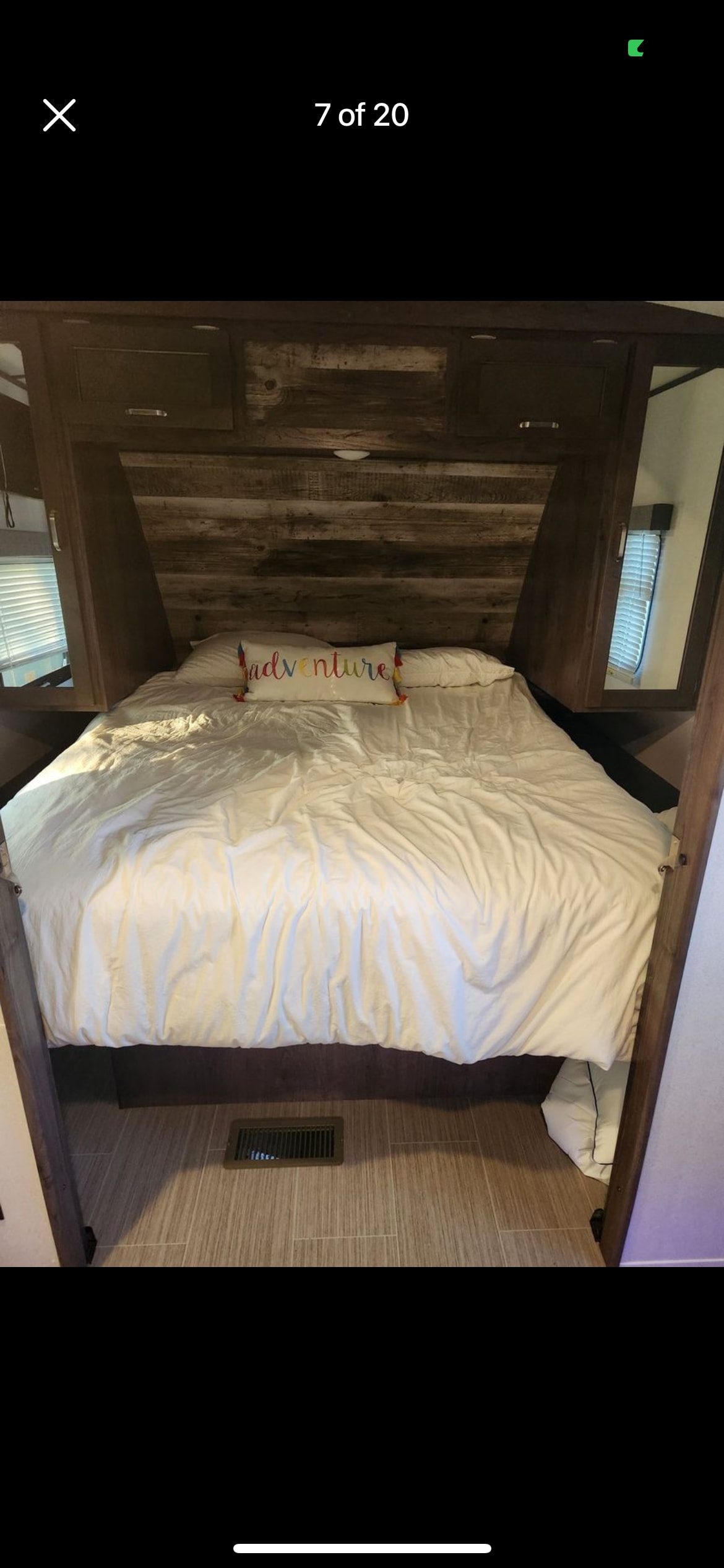 RV rental interior: This compact bedroom offers a comfy bed with an 'adventure' pillow & rustic wood paneling.. Keystone RV Passport GT 2021