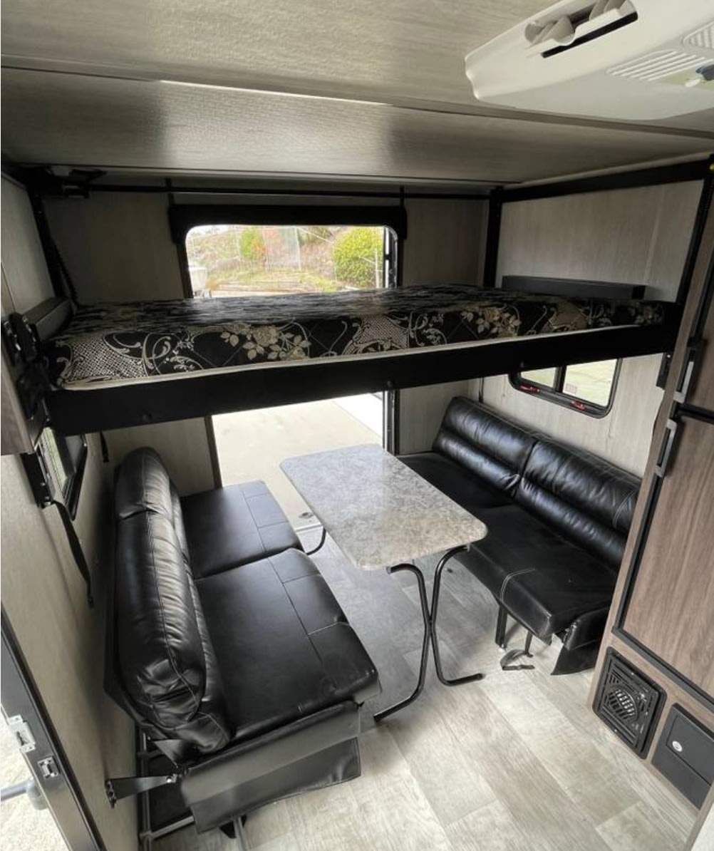 Top bunk and 2 lower beds and sitting area . Genesis Supreme Rv Overnighter 2023
